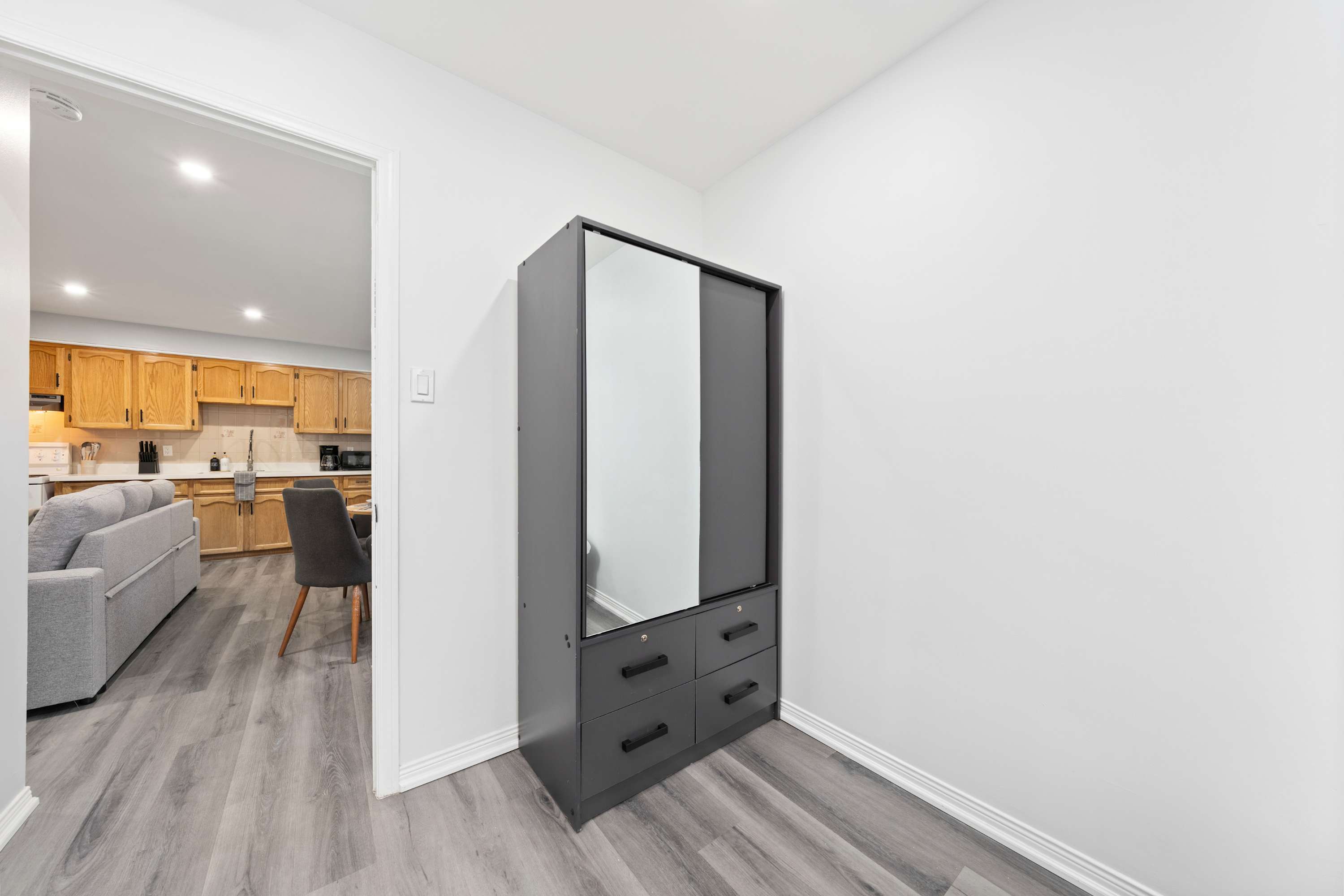 Step from a private bedroom into an open living space with seating and ambient light.