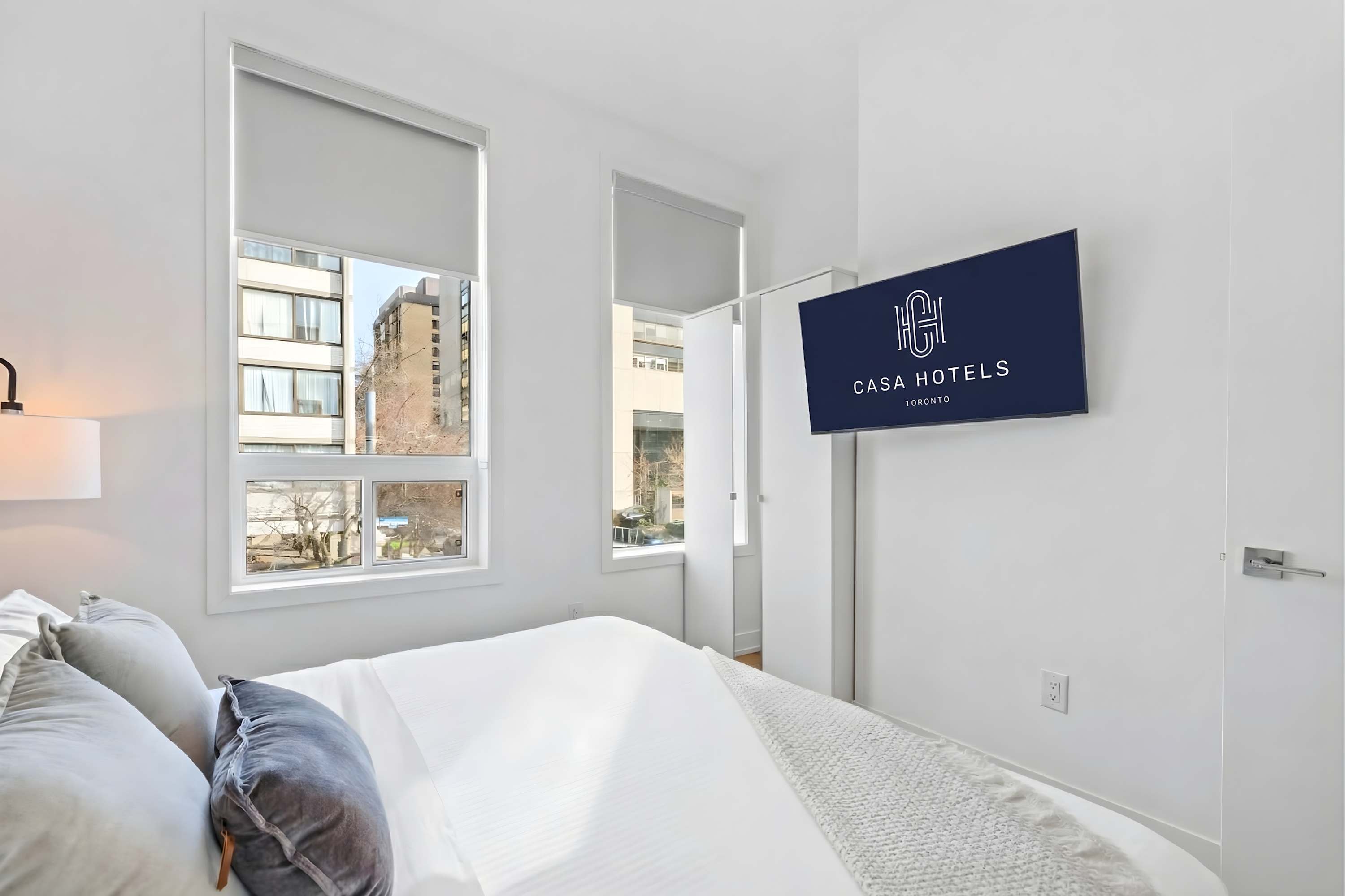 Bright bedroom with Smart TV and urban views.