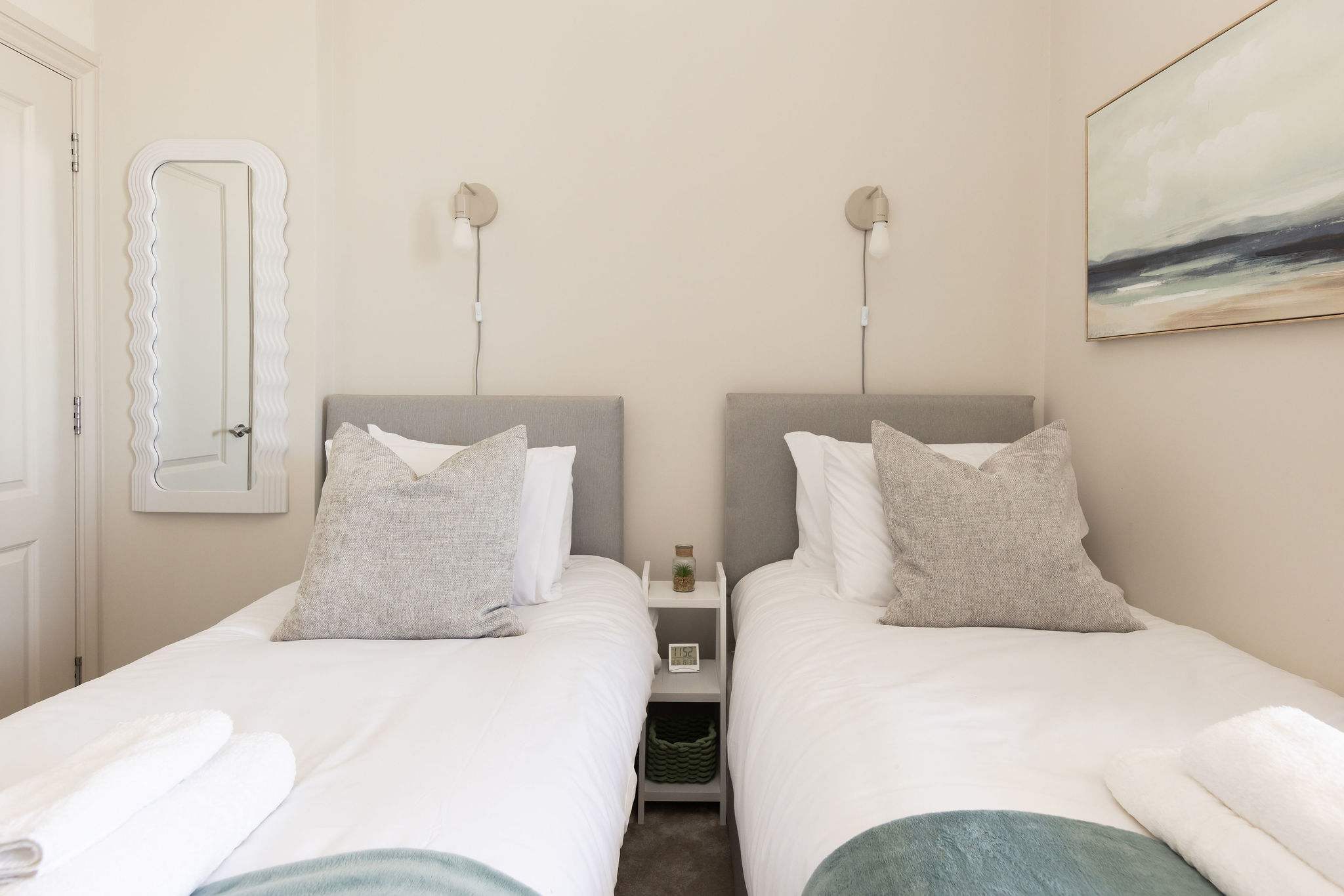 A calm and comfortable bedroom adds to the apartment’s relaxed coastal charm.