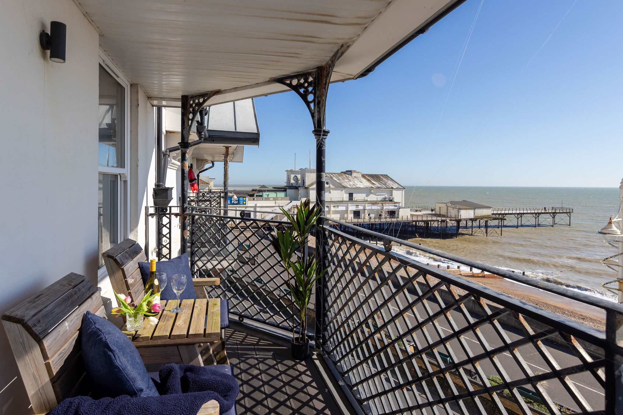 The private balcony offers a standout seafront setting with panoramic views across the coast.