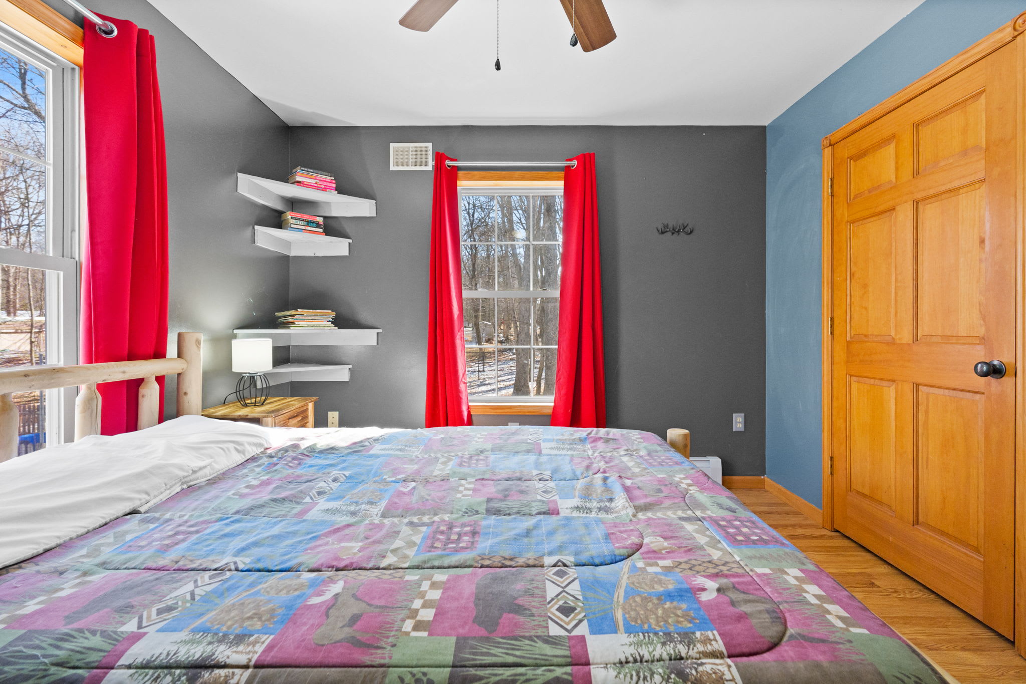 Another view of the charming bedroom with colorful quilt and natural light
