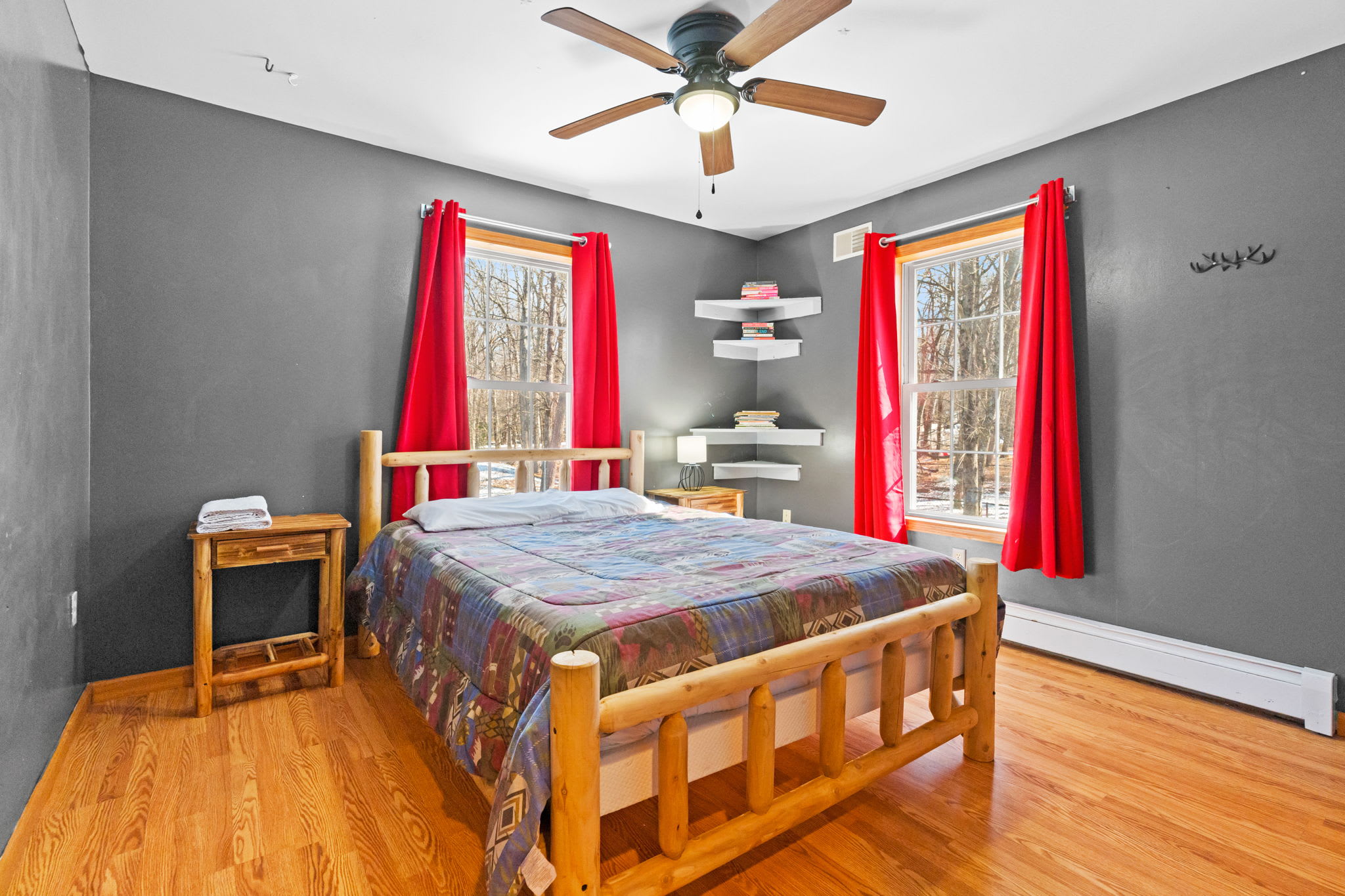 Wake up to wooded views through the red curtains in this log-frame bedroom