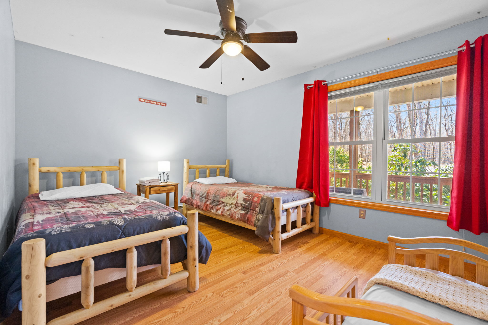 Bright bedroom with windows overlooking the wooded deck