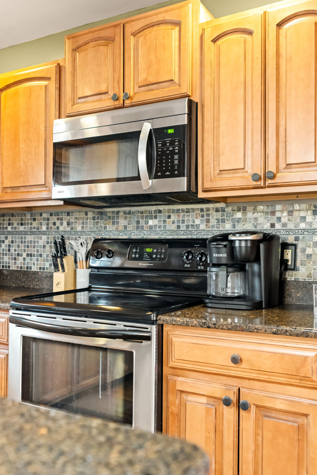 Stainless steel stove and mosaic backsplash make cooking a pleasure