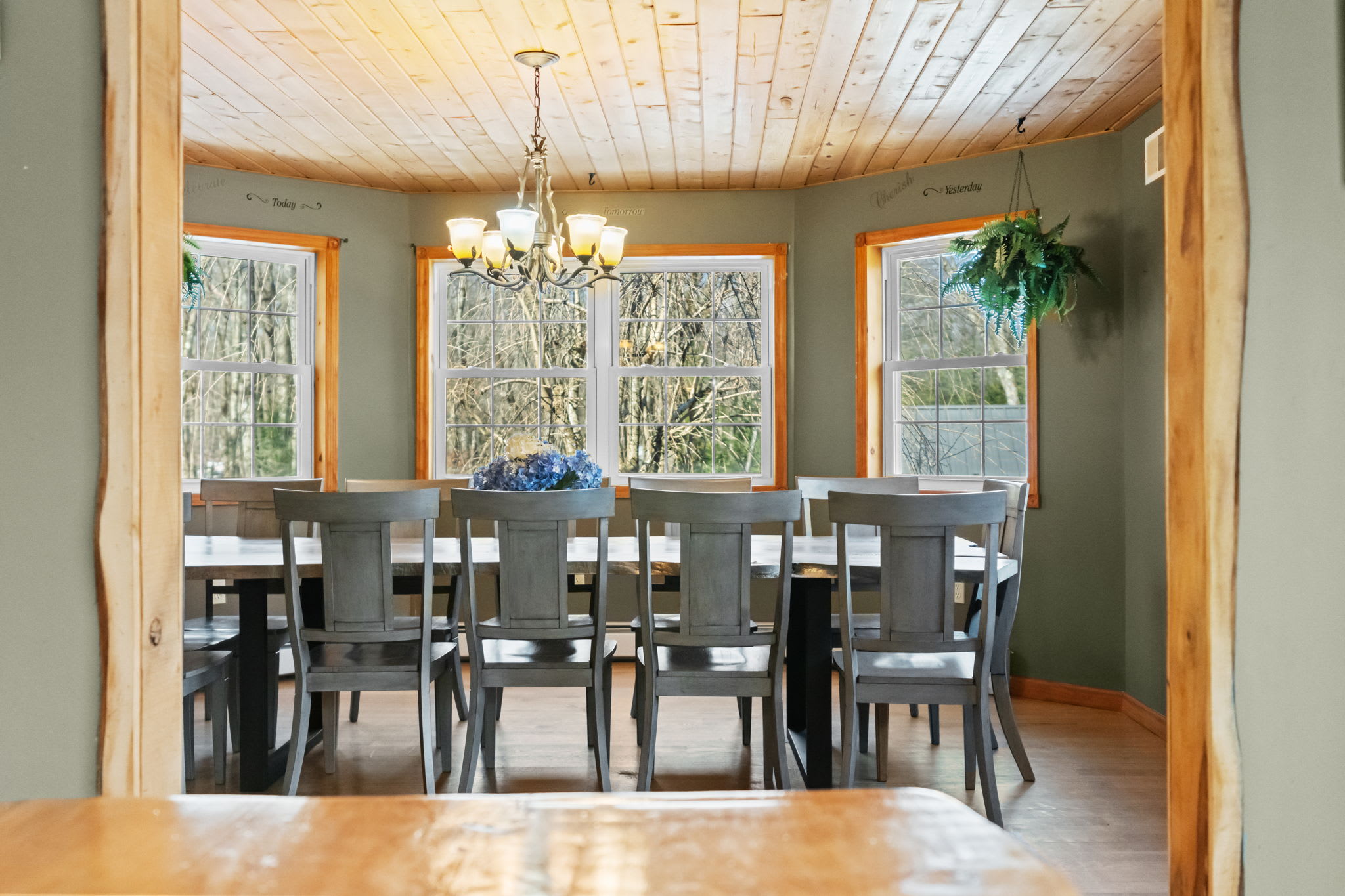 Spacious dining room with vaulted wood ceilings and windows on every side