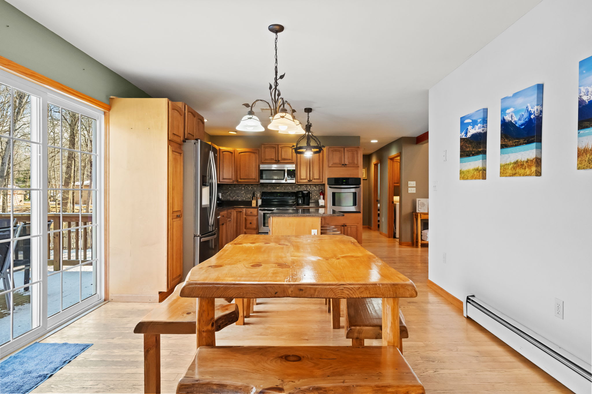 Dining nook with log accents, landscape art, and a handcrafted bench