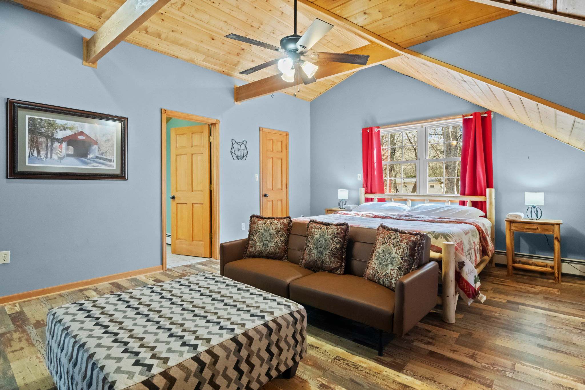 Cozy cabin bedroom with framed art on teal walls and a quilted bedspread