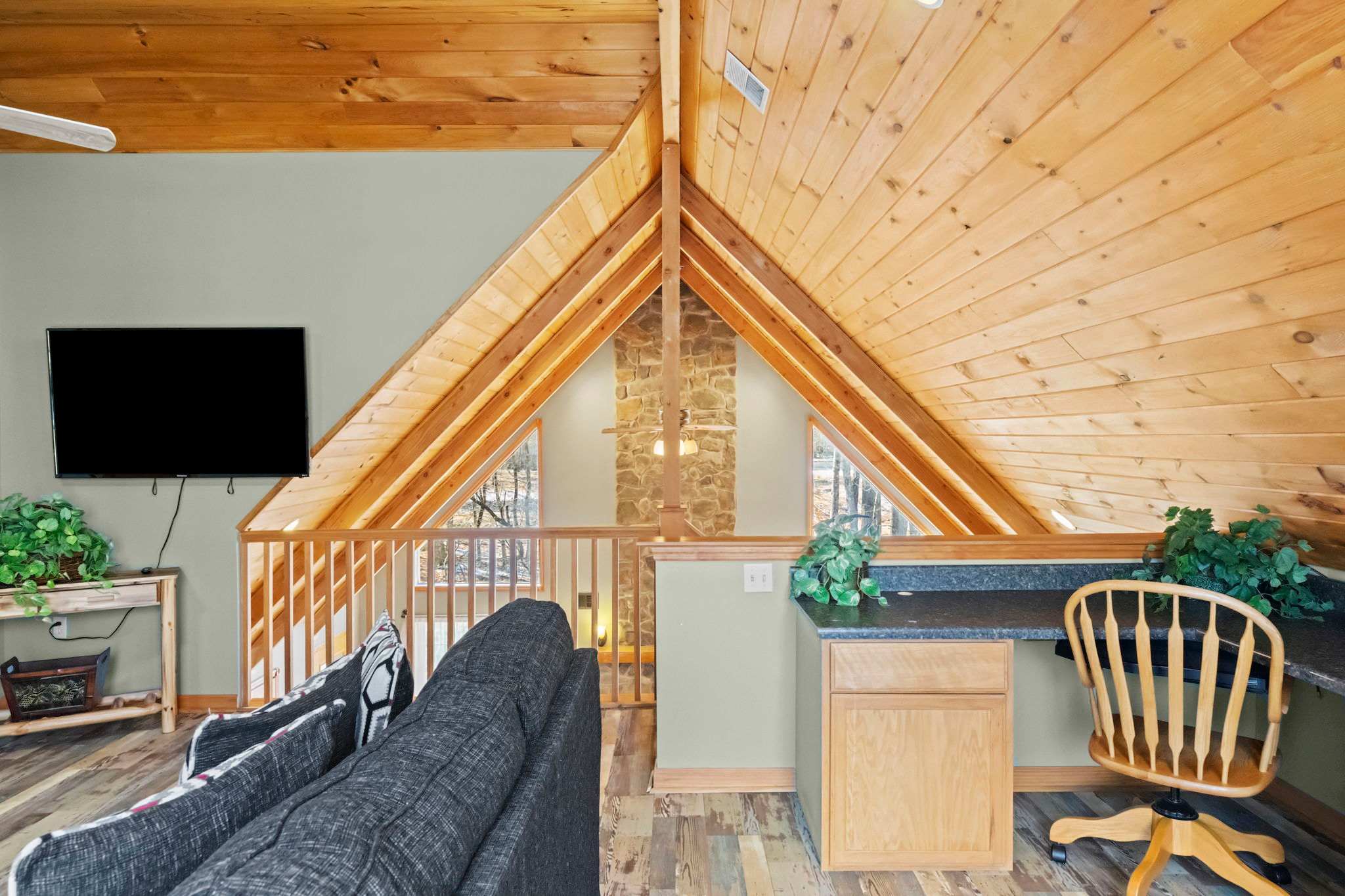 Tucked-away loft sleeping area with wooden walls and a window view