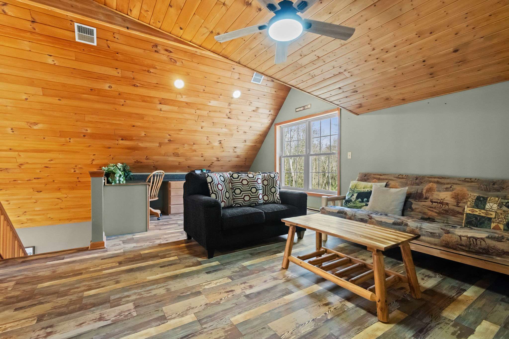 Open loft space with soaring A-frame beams and golden hardwood floors