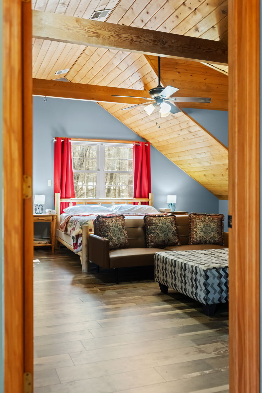 The A-frame interior glows with warm wood tones from floor to peak