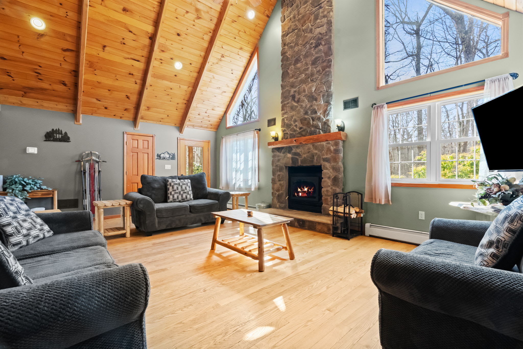 A bird's eye view of the living room with the stone fireplace glowing