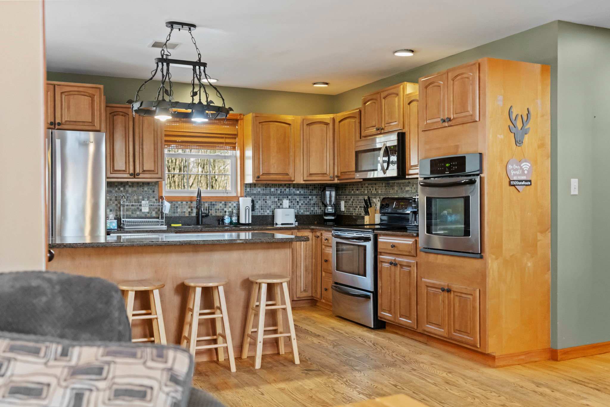 Spacious kitchen with wood cabinets, a breakfast bar, and pendant lights