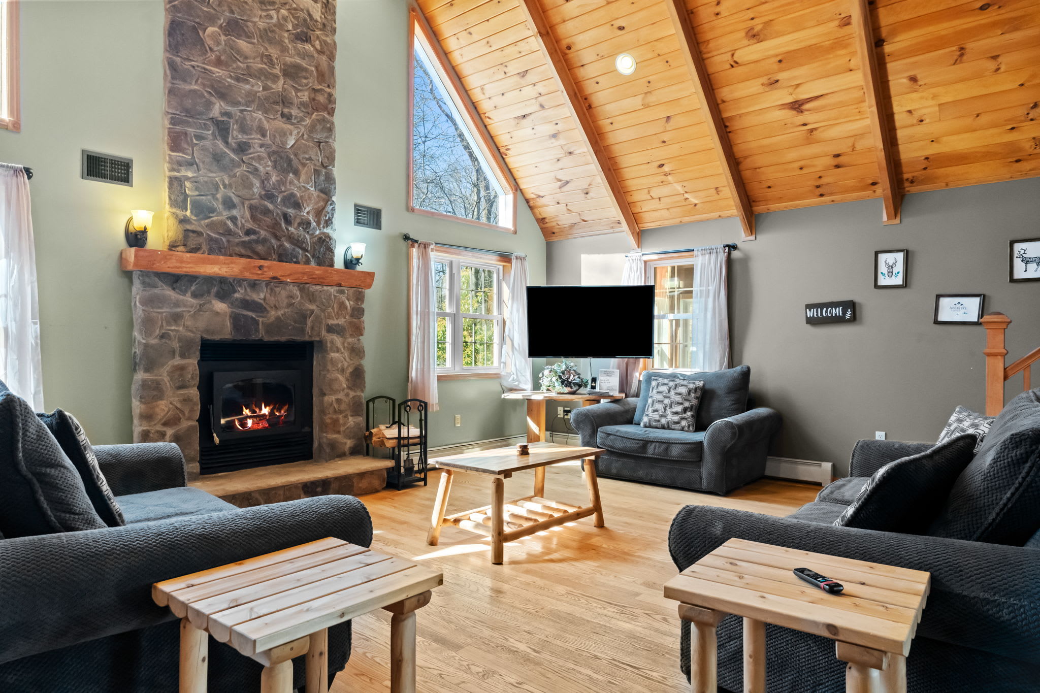 Gather in the main living room with plush couches and a stone fireplace