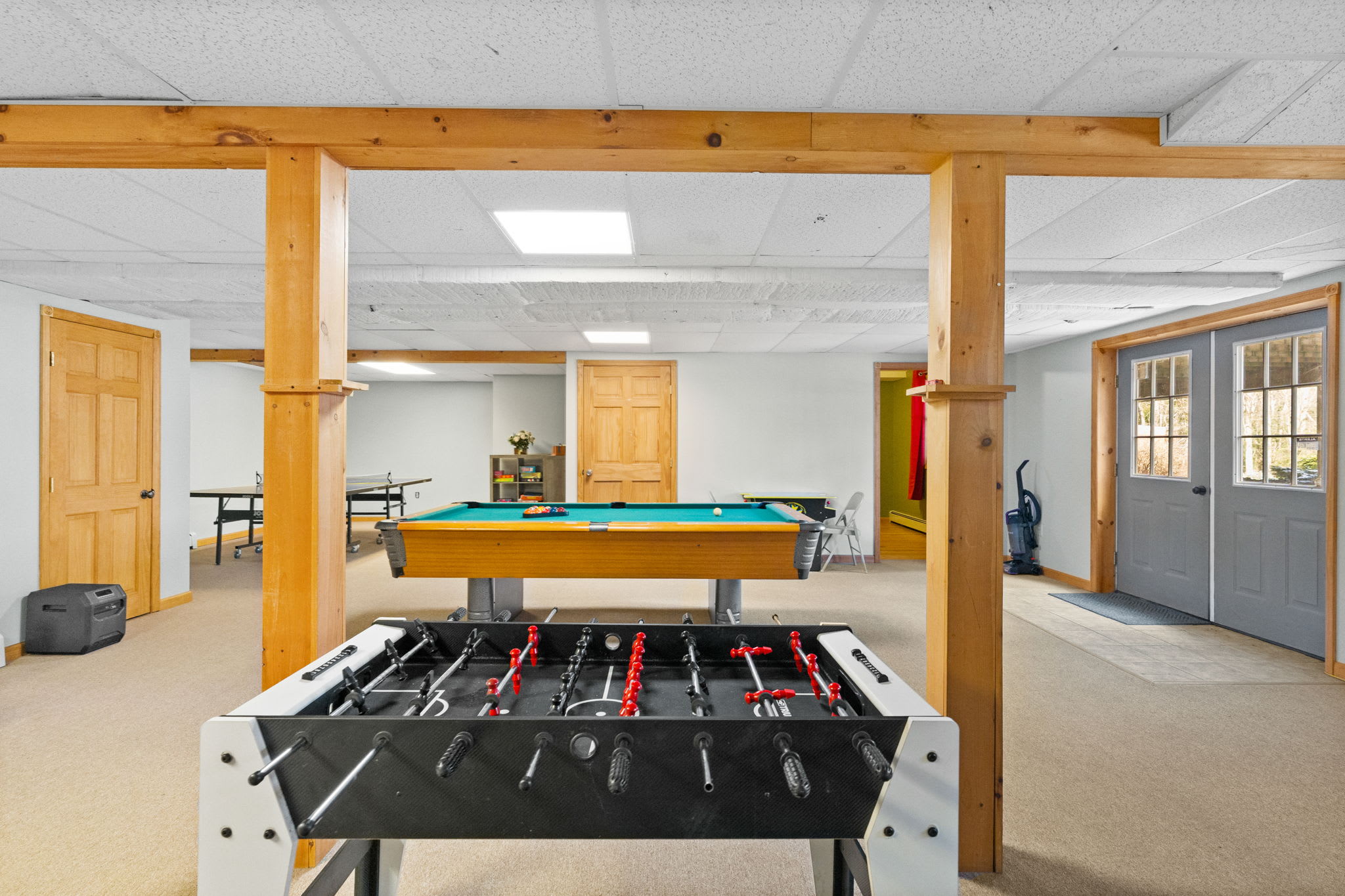 Wide-open game room with a pool table and red cup displays ready for tournament night