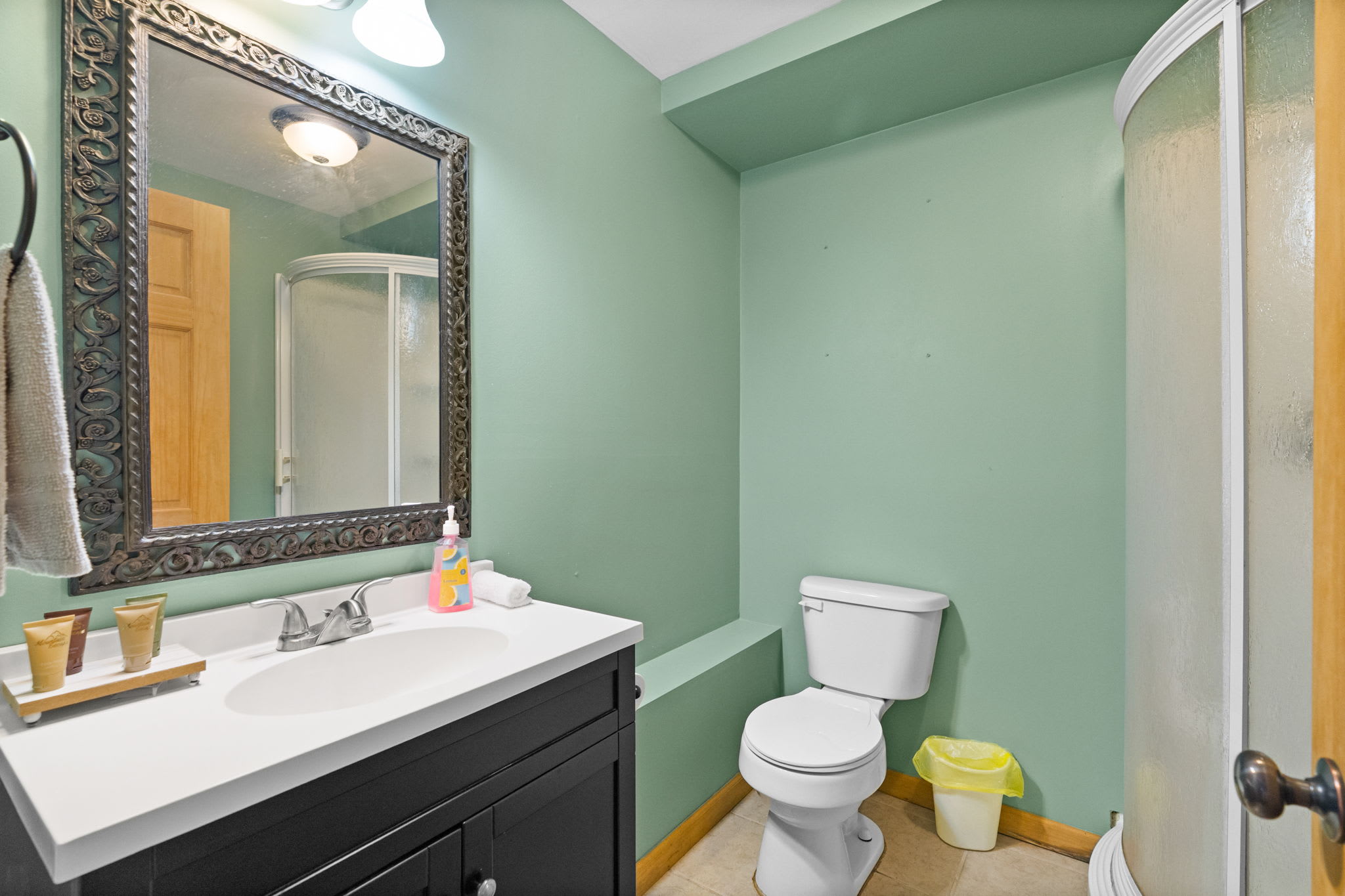 Bath with a dark wood vanity and warm cabin-style paneling throughout