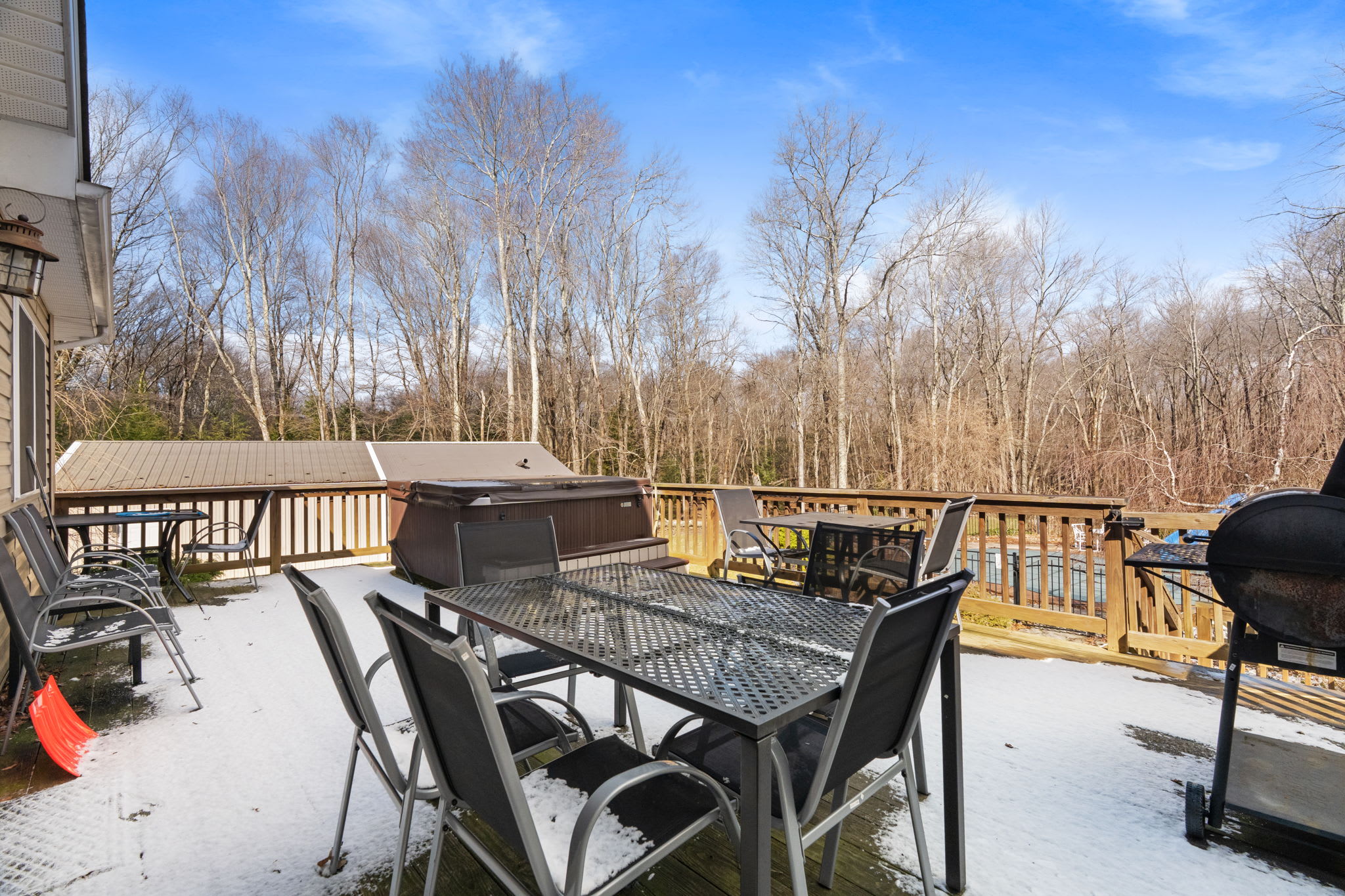 Spacious deck with a grill, hot tub, and dining table for outdoor meals