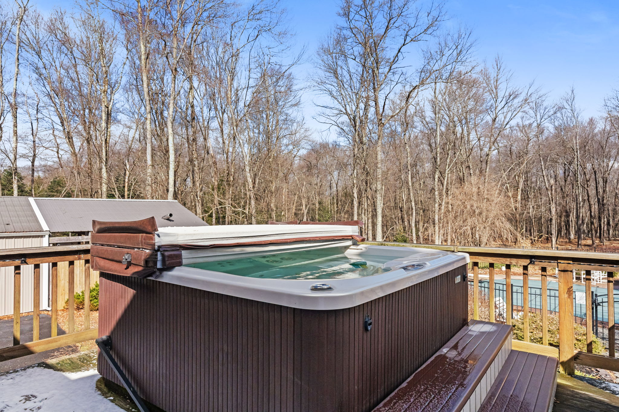 Unwind in the private hot tub on the deck with views of the surrounding woods