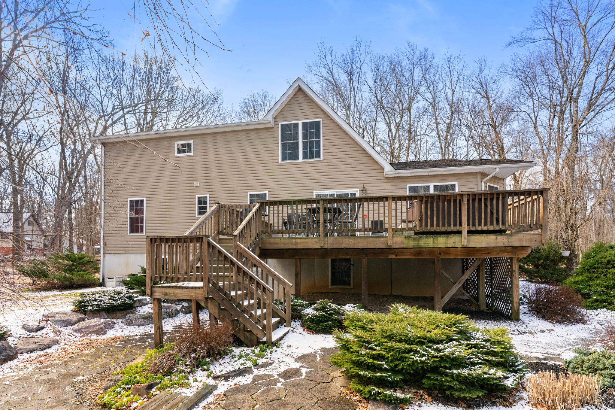 The multi-level Pocono cabin from the yard with wrap-around decks and wooded backdrop