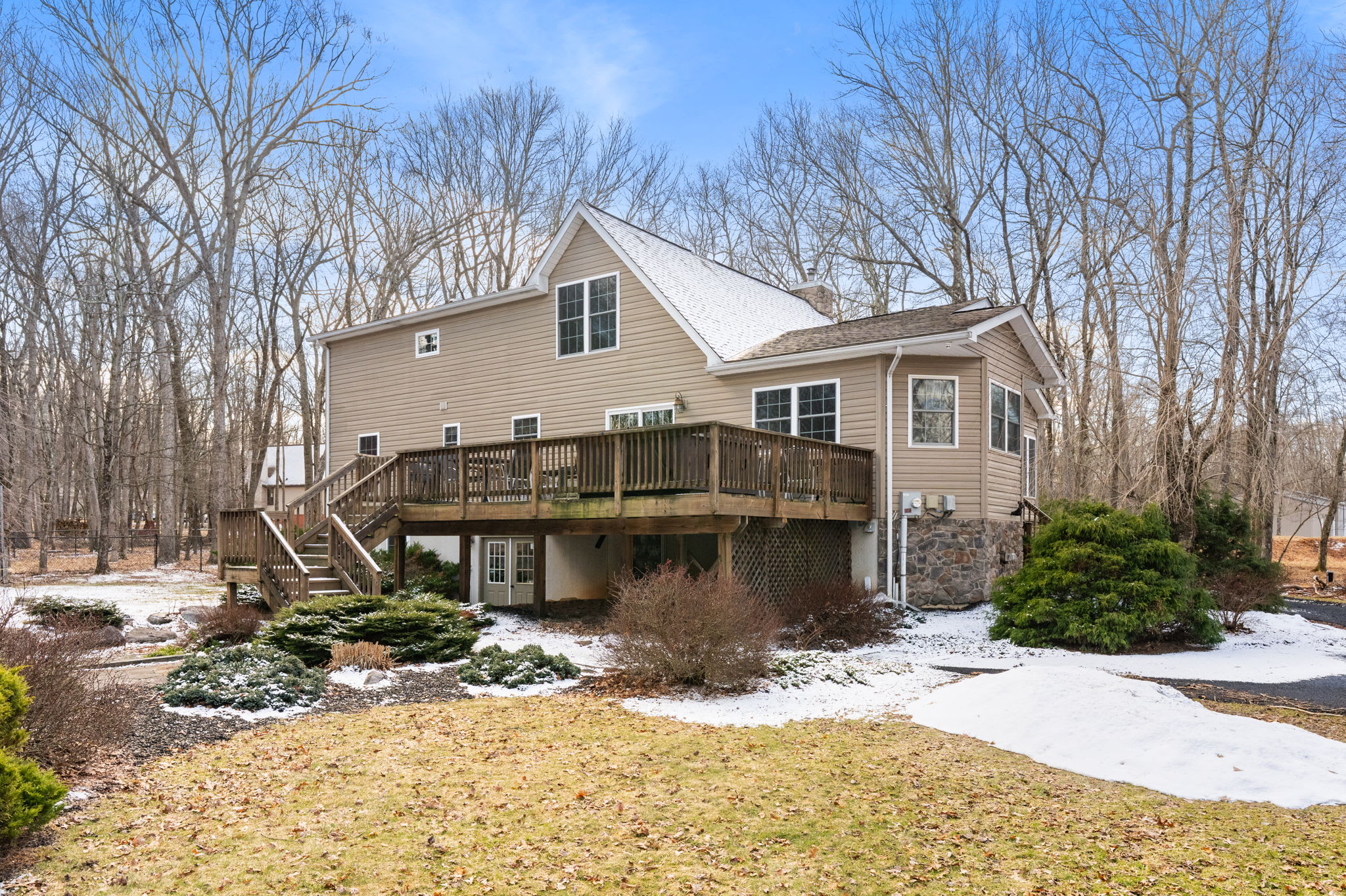 Front view of the cabin retreat with landscaped yard and mature trees all around