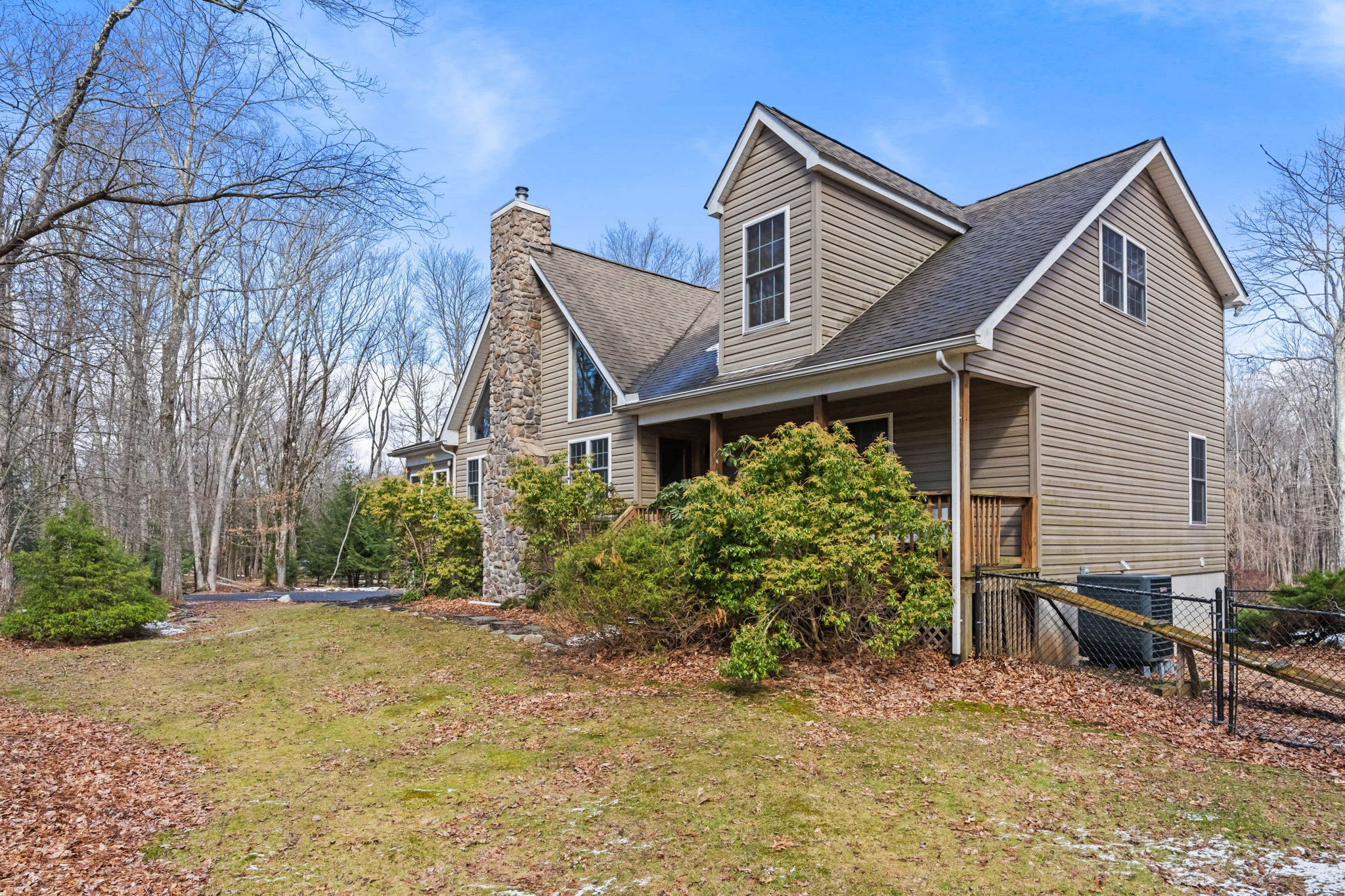 The cabin's warm exterior with natural wood siding framed by the surrounding forest