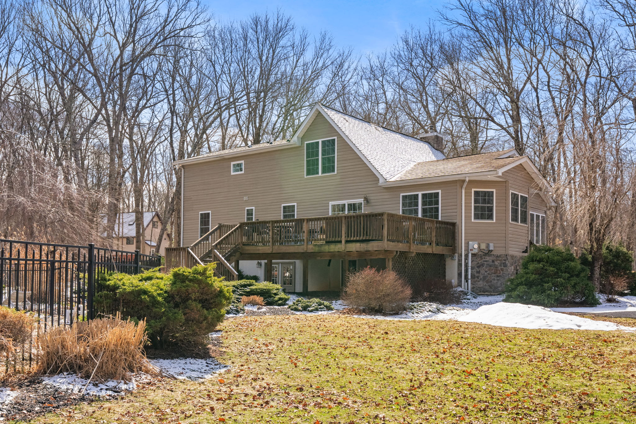 Backyard view of the mountain cabin with open green space and towering hardwoods