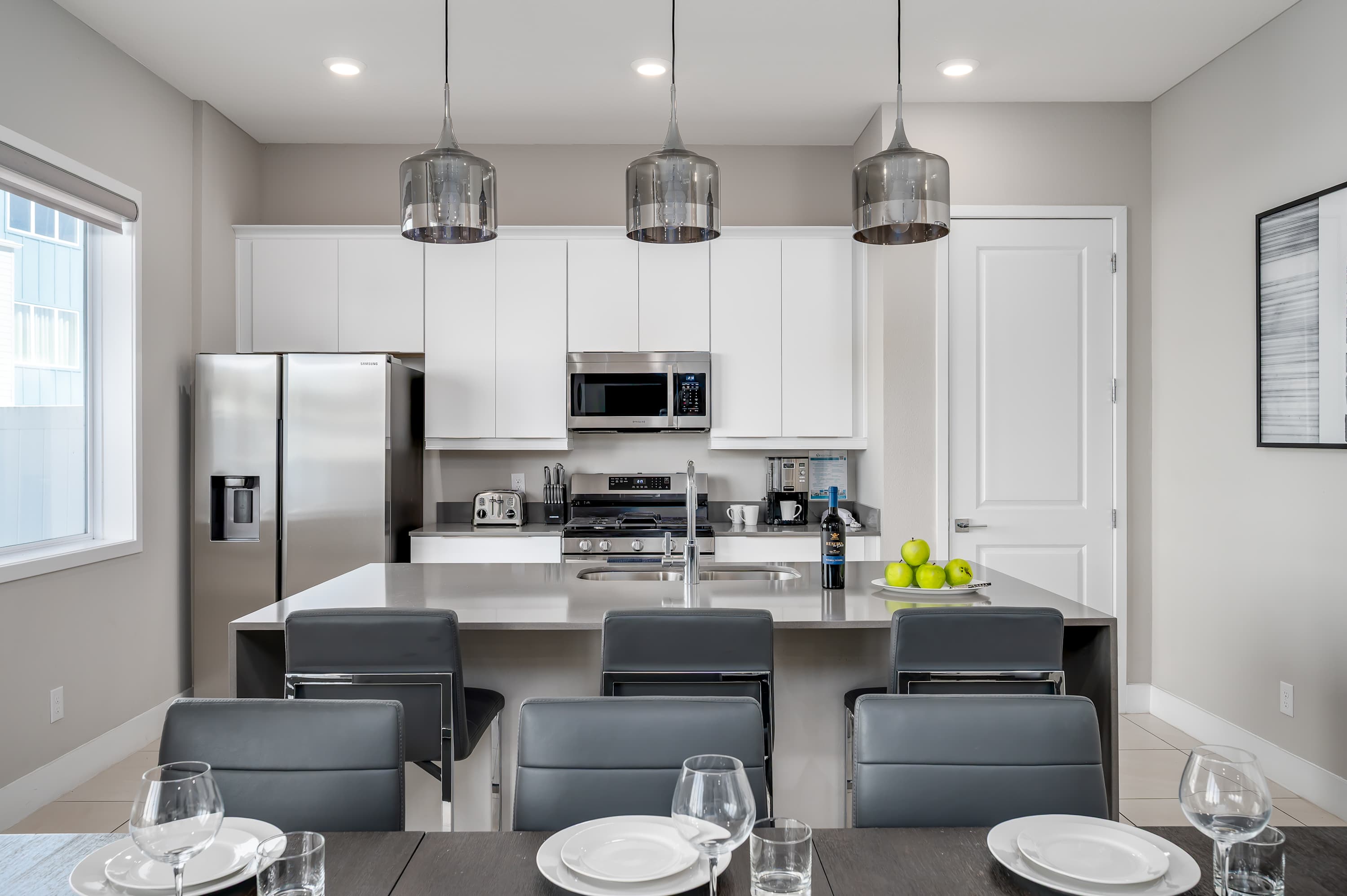 Modern kitchen with stainless steel appliances and a large island for casual dining.