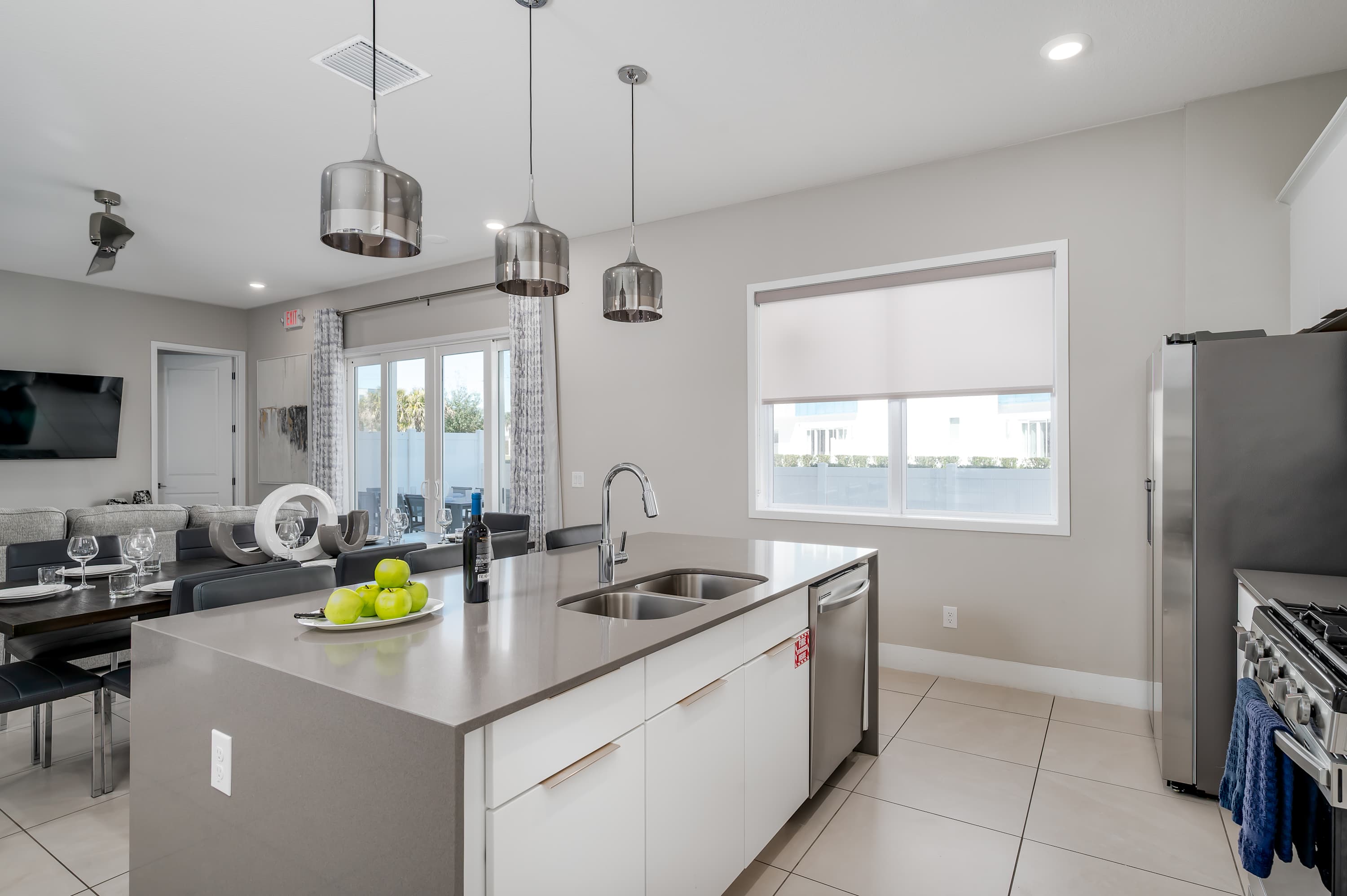 Modern kitchen island with stainless steel appliances and pendant lighting