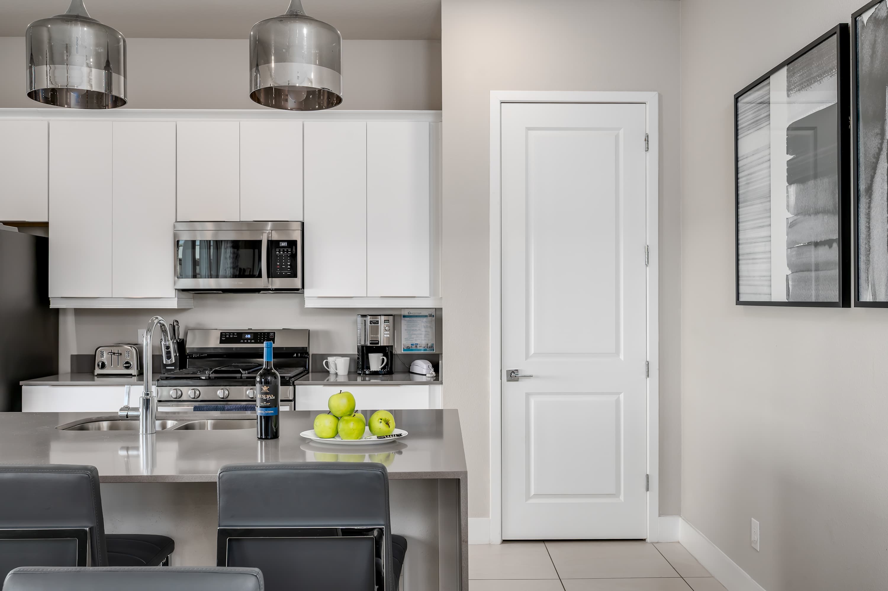 Modern kitchen with stainless steel appliances and a central island for casual dining.