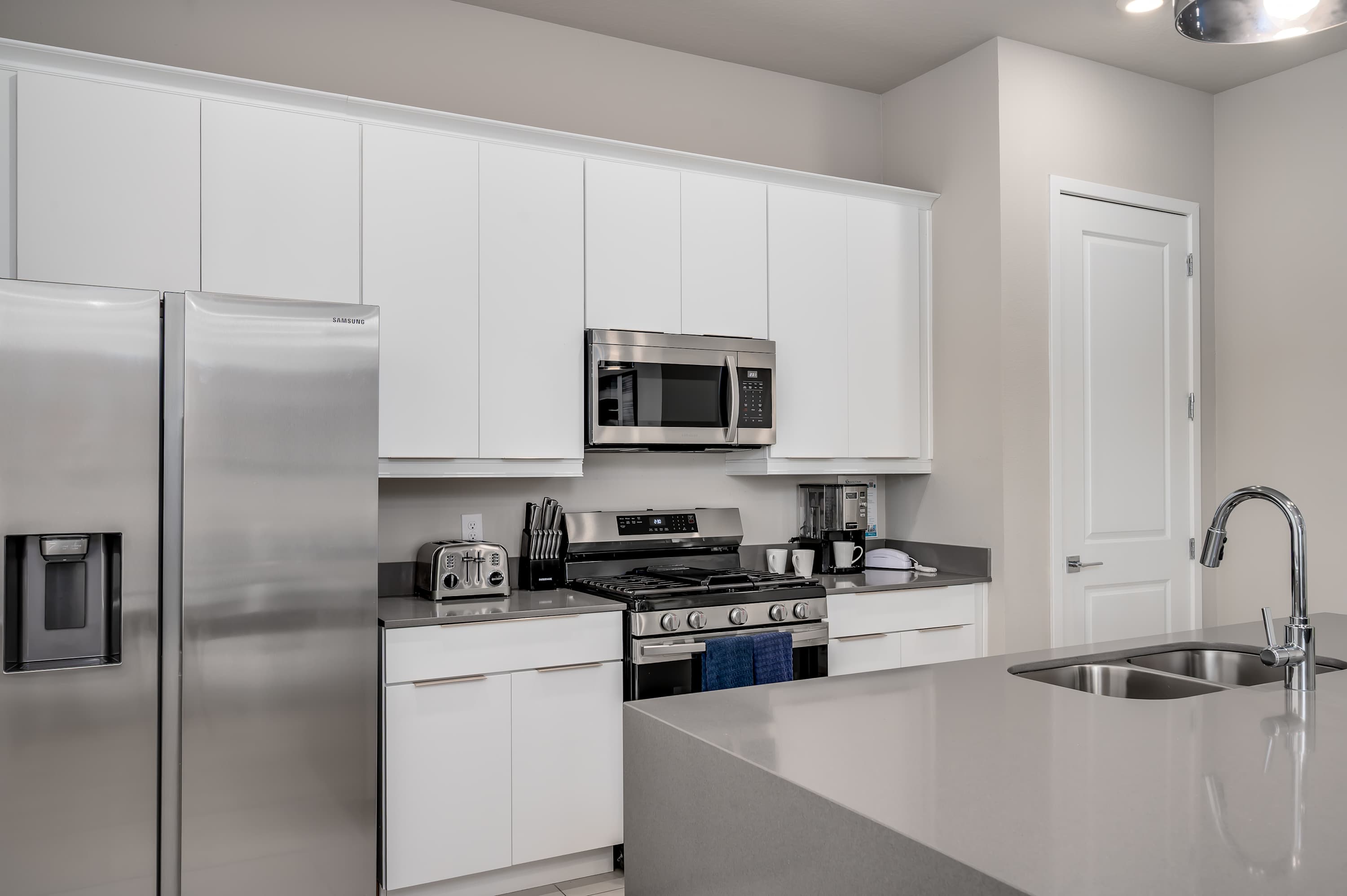 Modern kitchen with stainless steel appliances and a large island for meal preparation.