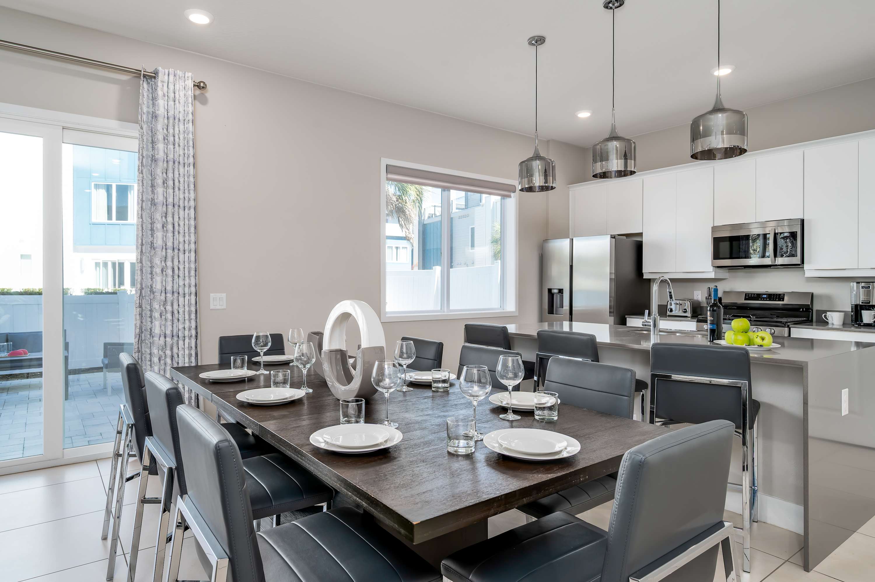 Modern kitchen and dining area with seating for ten and stainless steel appliances