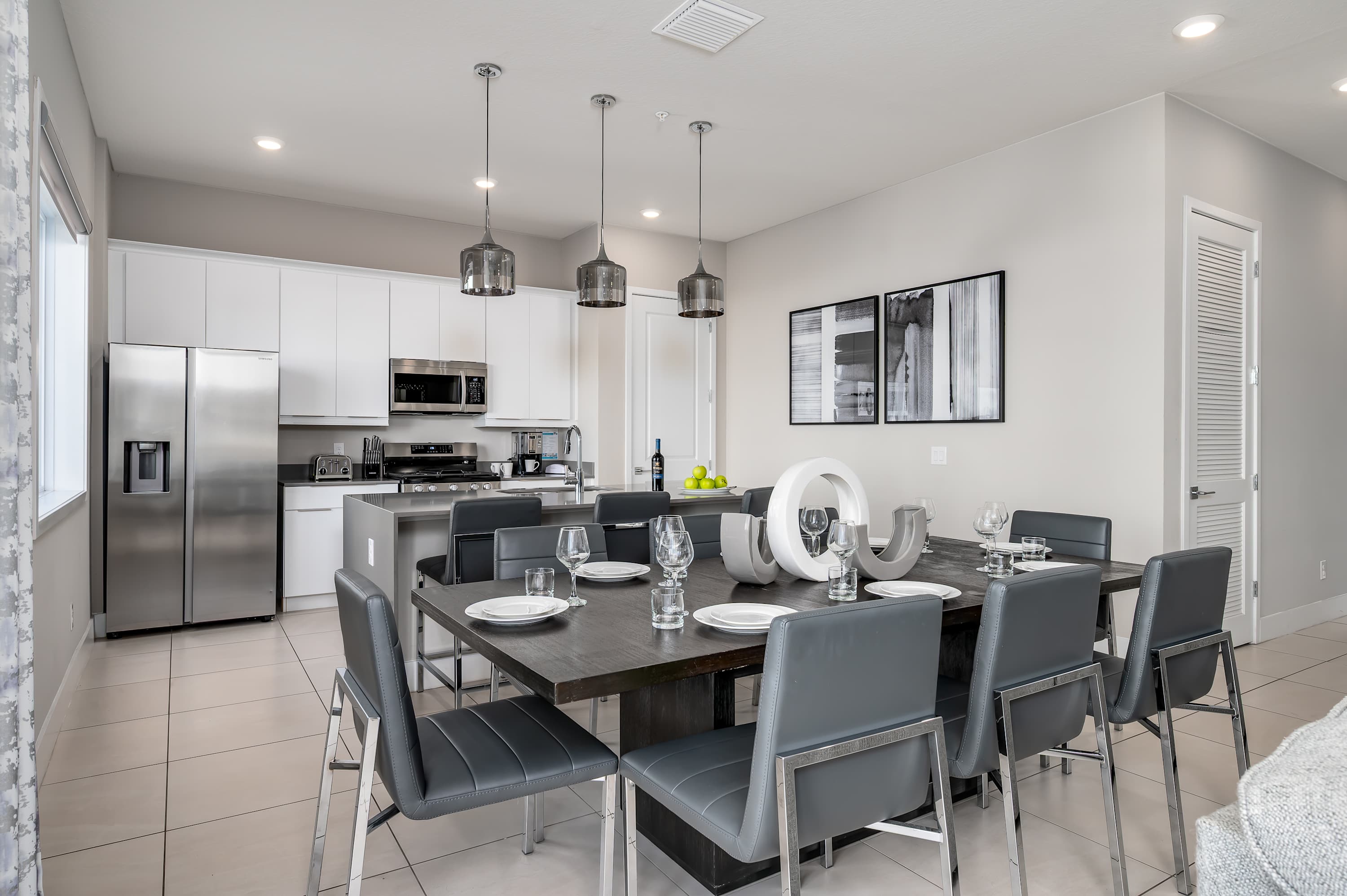 Modern kitchen and dining area with stainless steel appliances and seating for eight.