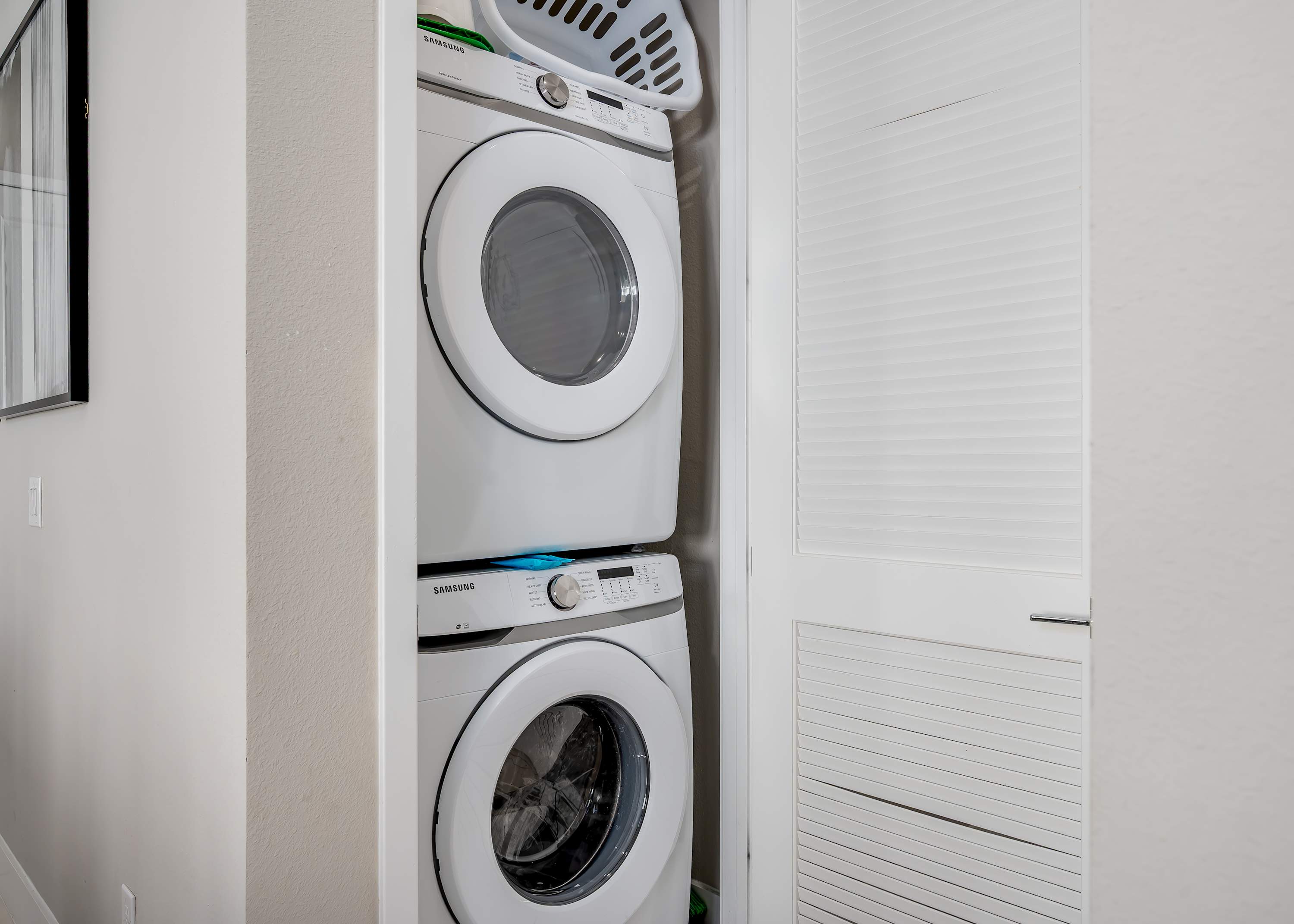 Stacked washer and dryer in a compact laundry closet for convenient use.
