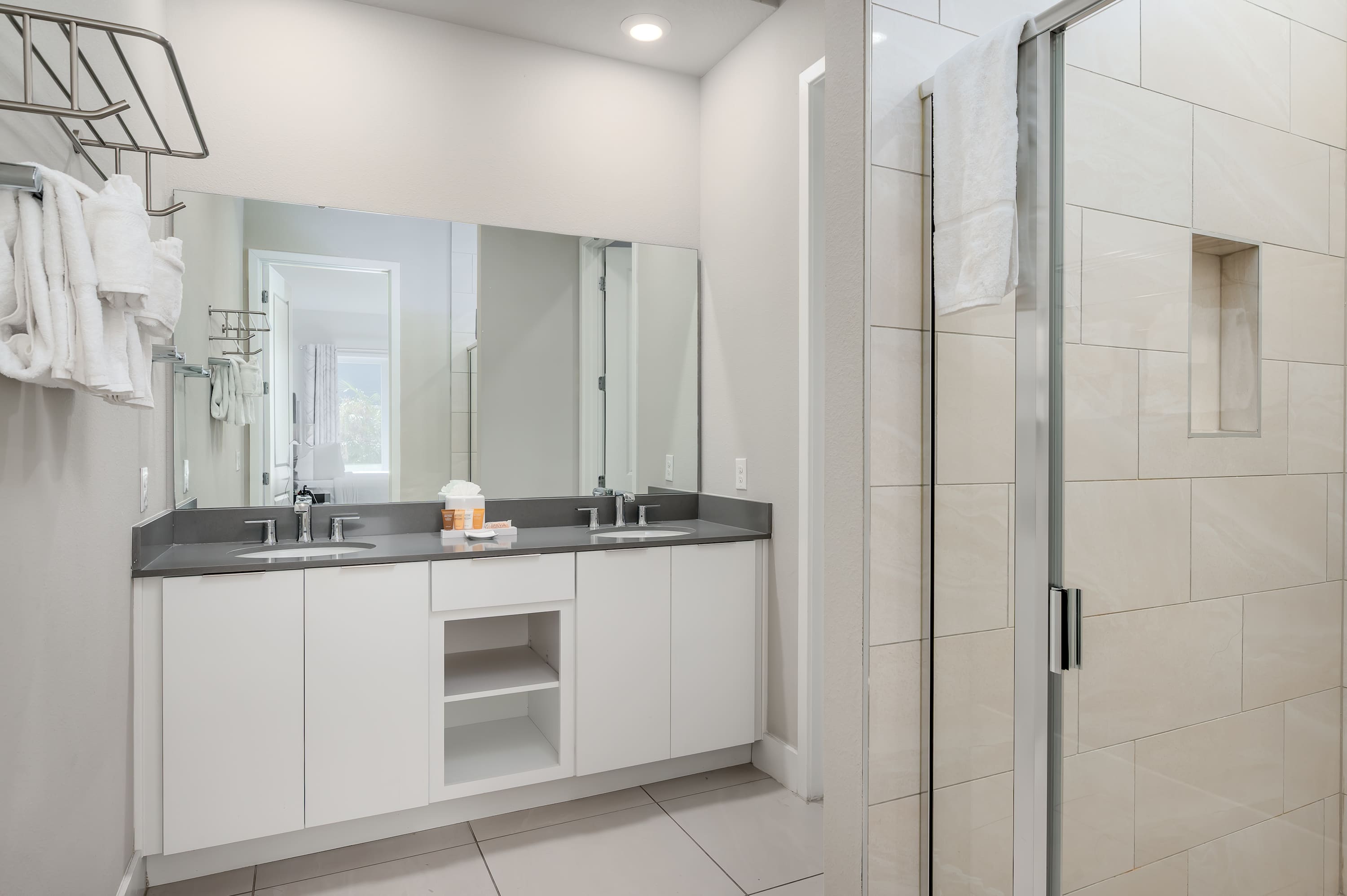 Modern bathroom with dual sinks and a glass-enclosed shower