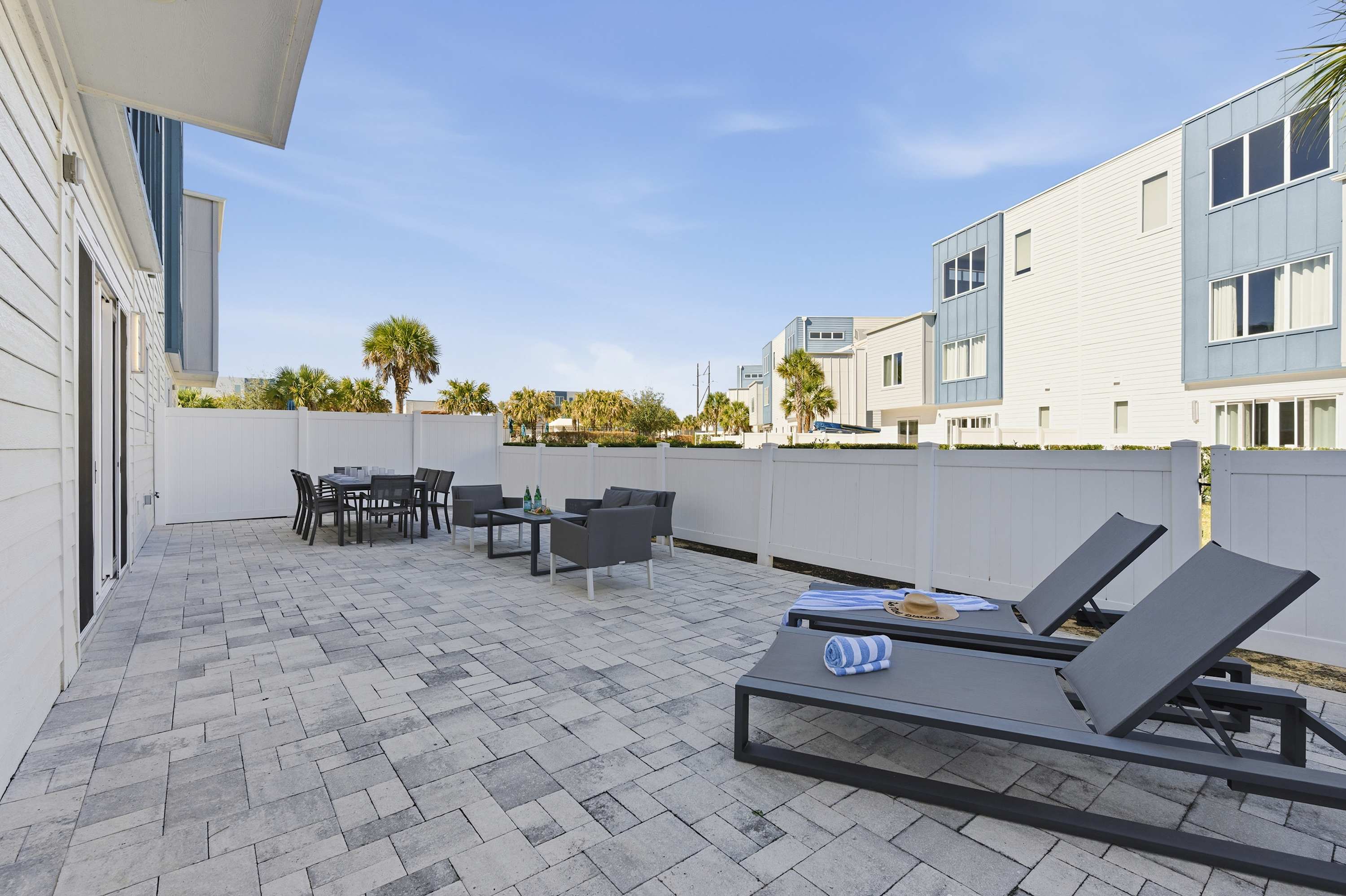 Spacious outdoor patio with lounge chairs and dining area for relaxing and entertaining.