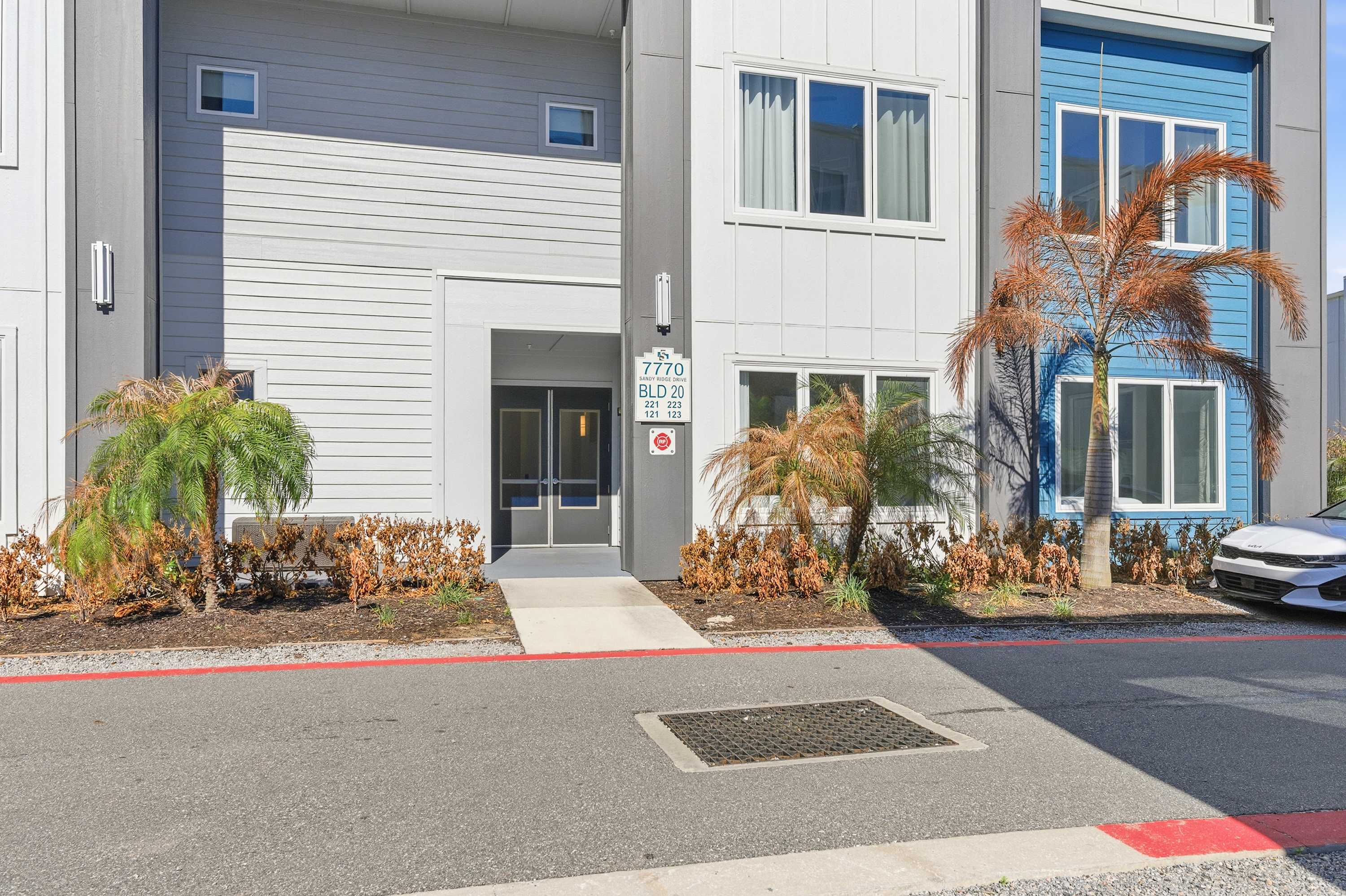 Modern apartment building entrance with blue and gray exterior accents