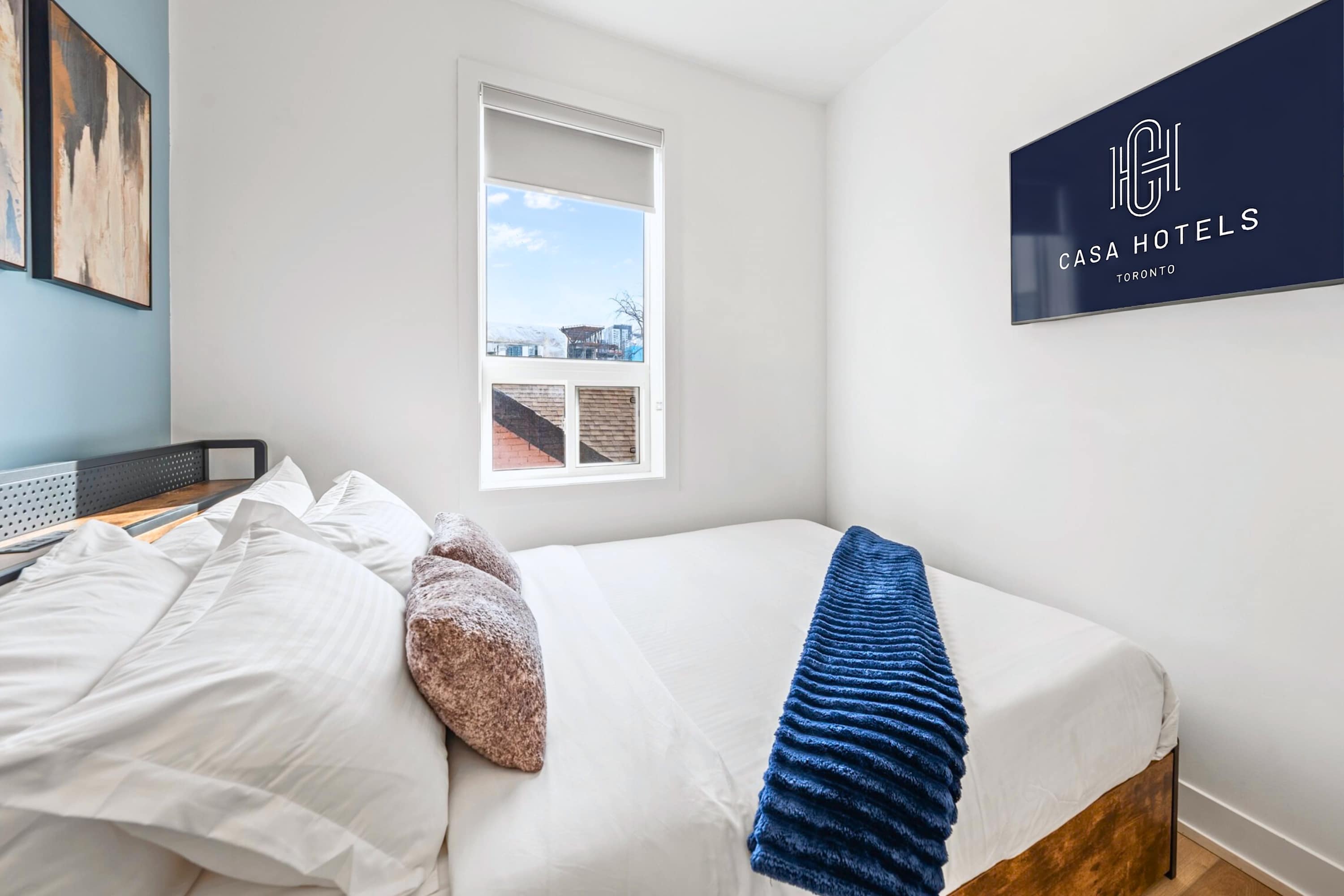 Modern bedroom with large window and city views.
