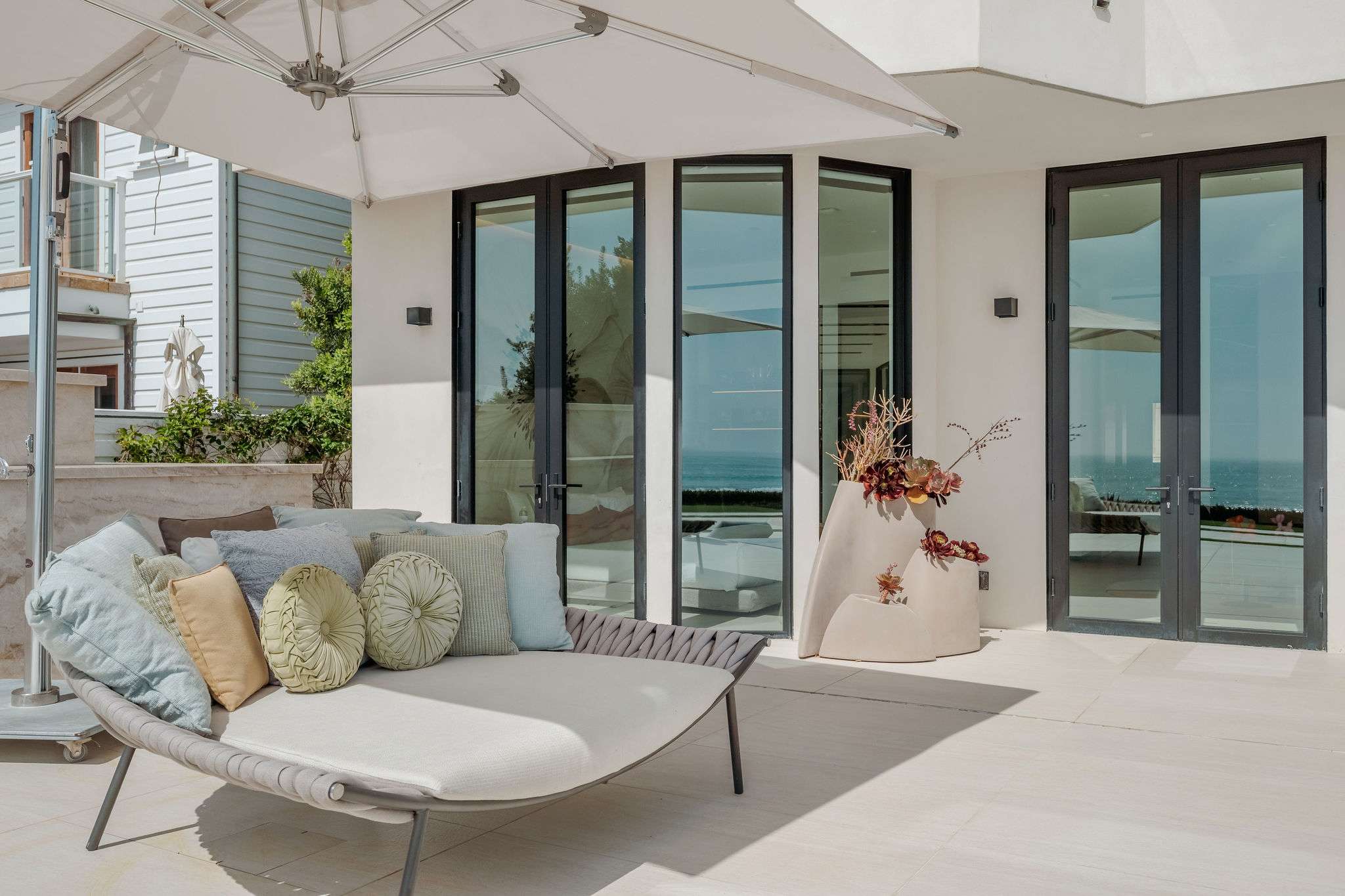 Covered oceanfront lounge with sculptural seating and panoramic coastal views.