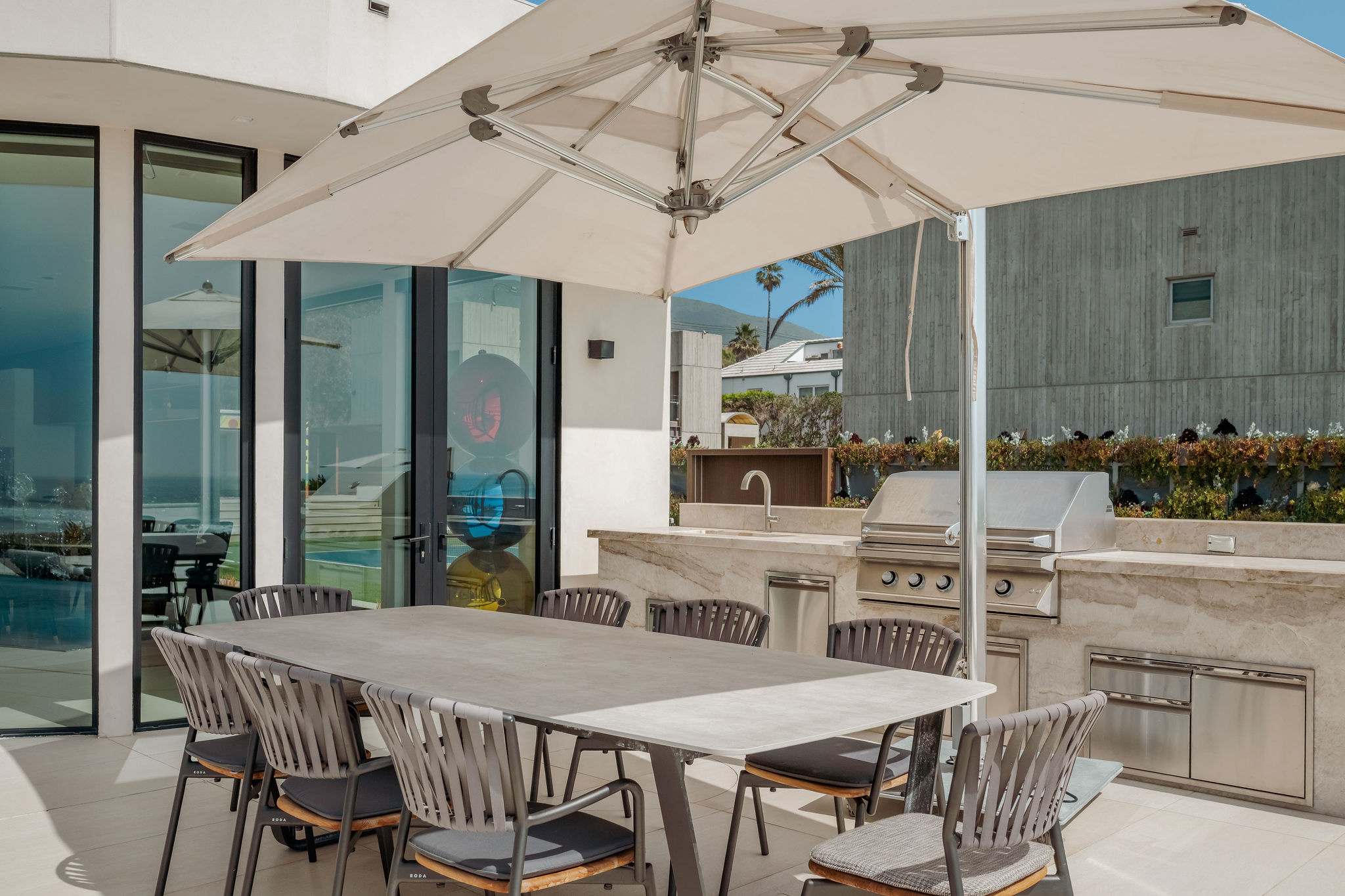 Oceanfront outdoor dining with shaded seating and direct beach access.