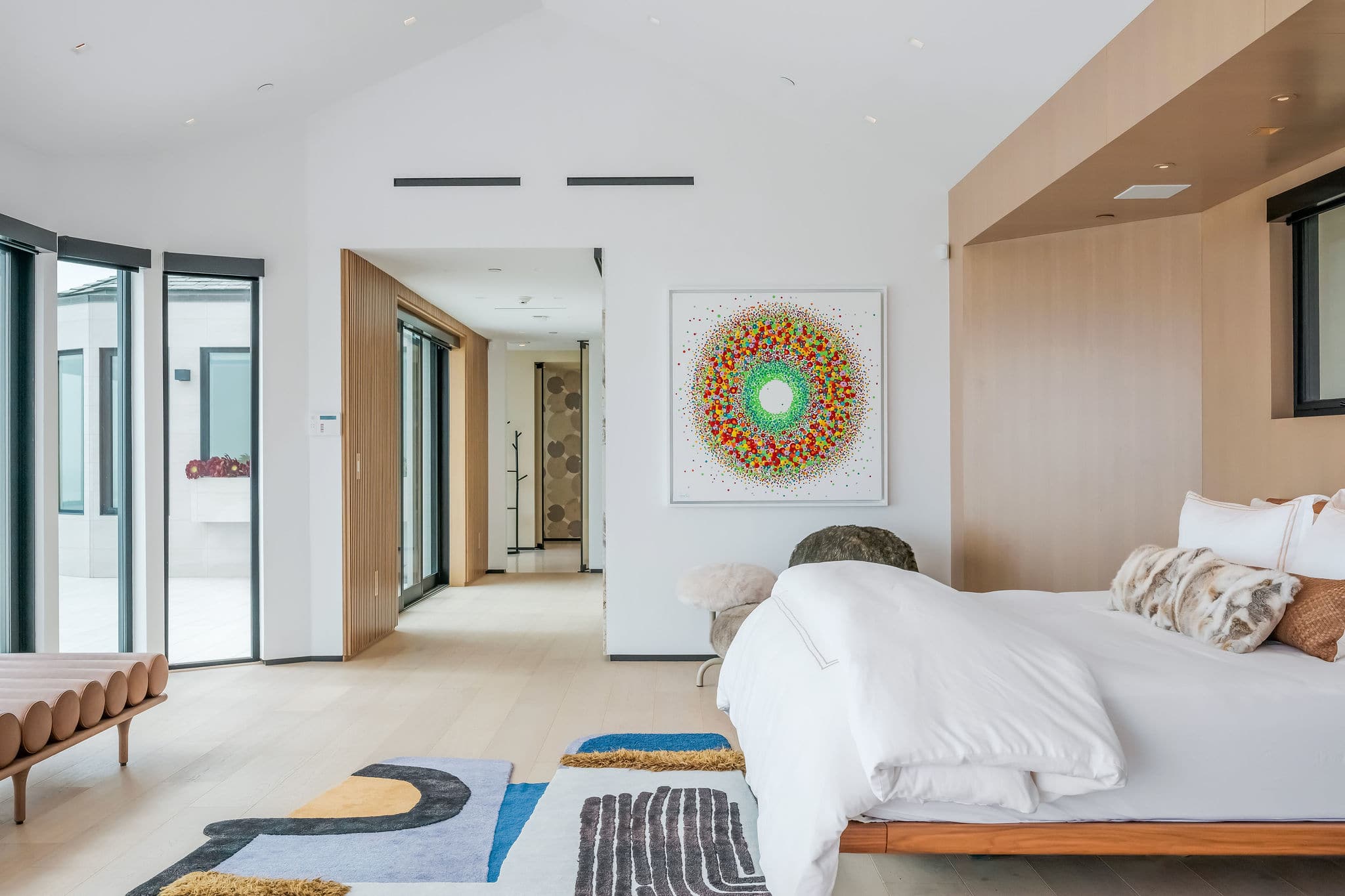Guest bedroom with curated artwork and integrated lounge seating.