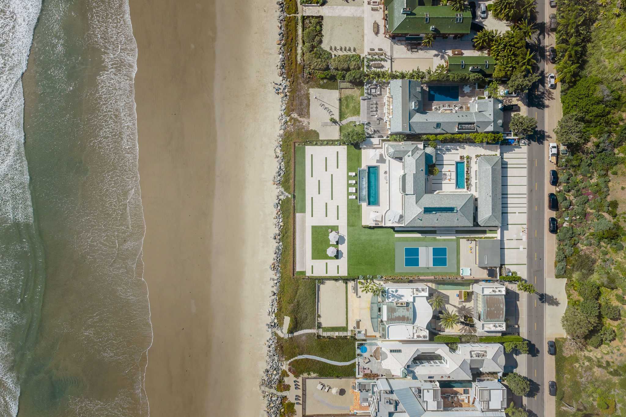 From above, the full beachfront layout unfolds from the home to the sand.