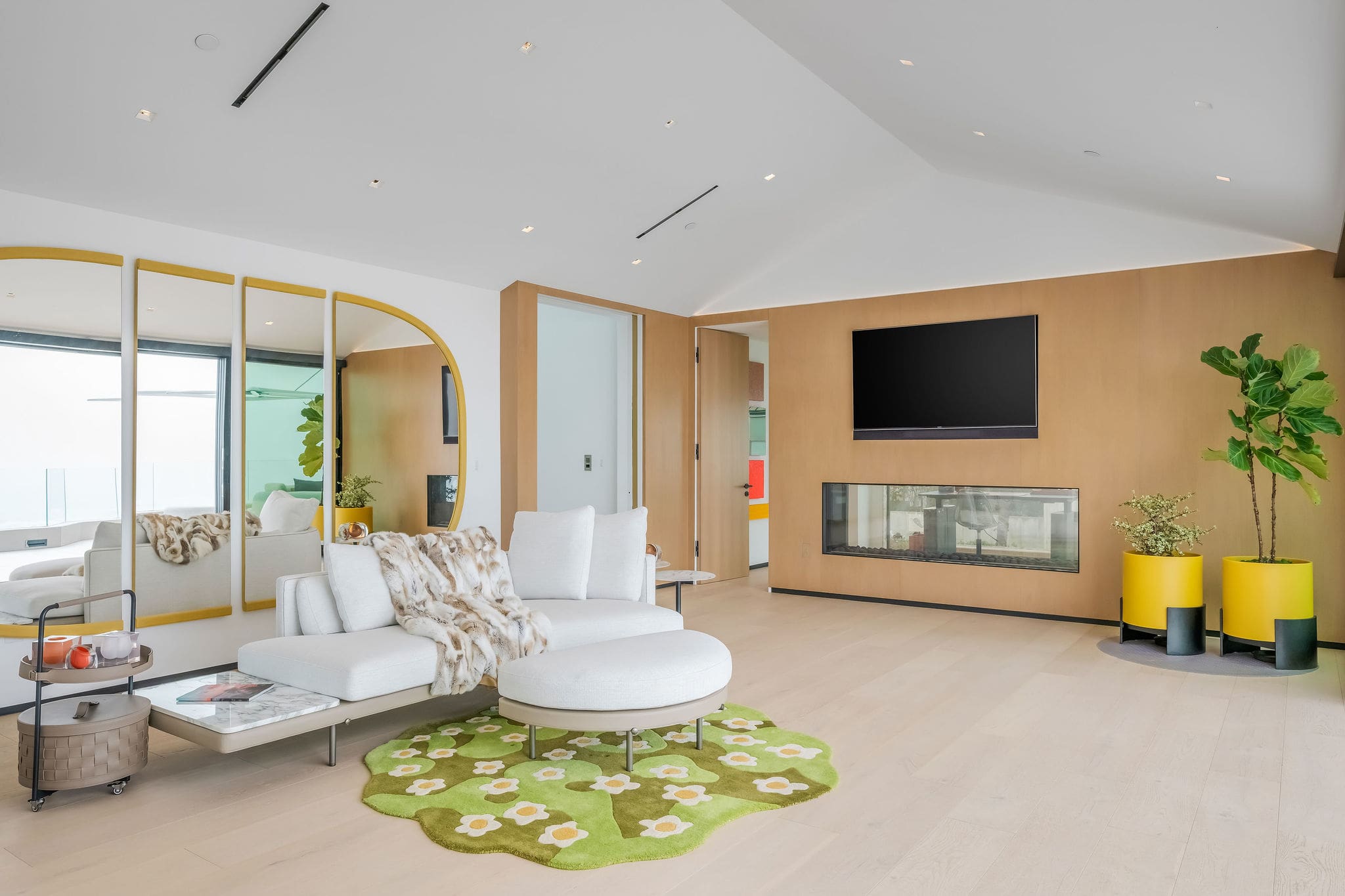 Bedroom suite with media wall, lounge seating, and modern finishes.