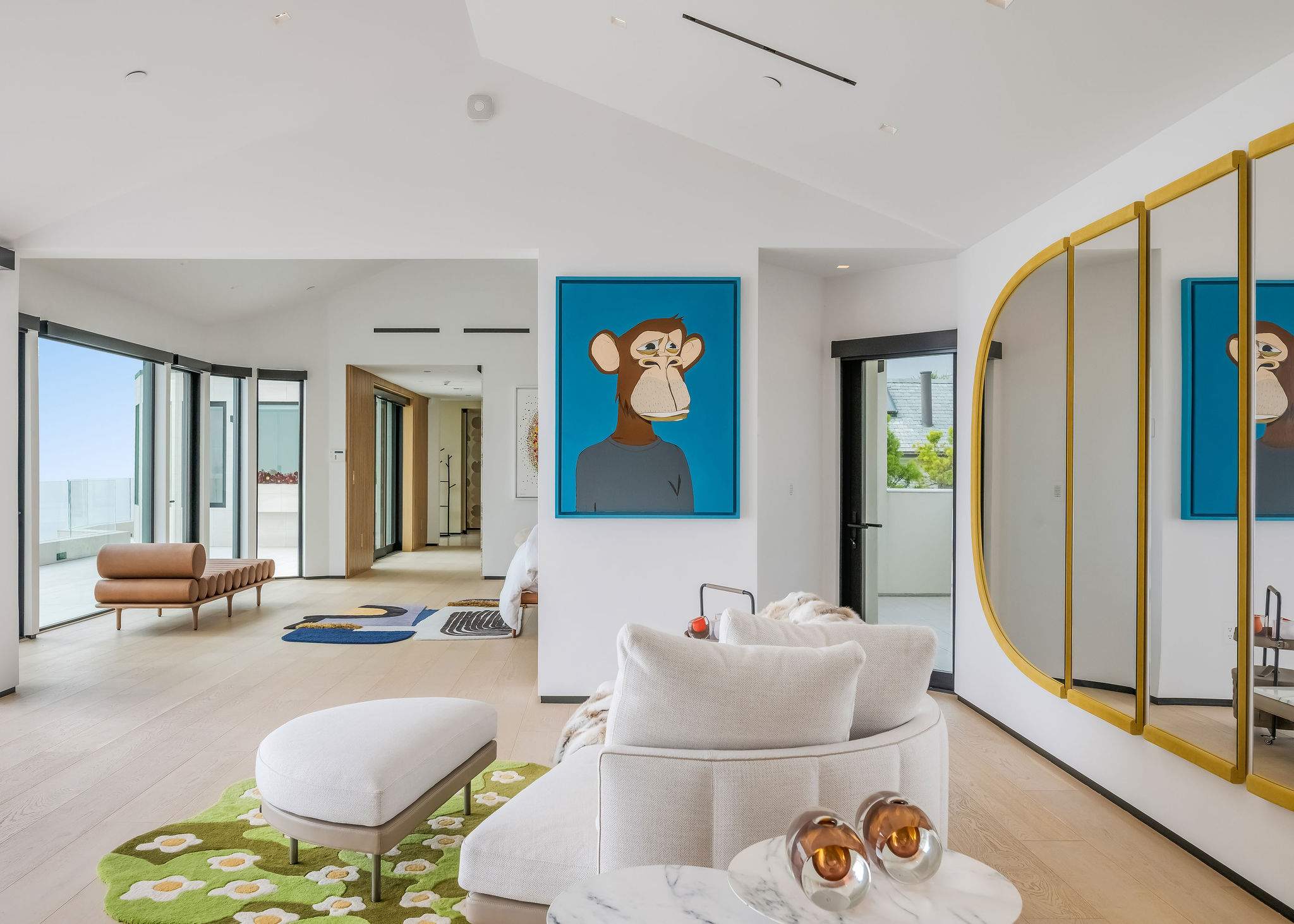 Designer bedroom with mirrored feature wall and statement artwork.