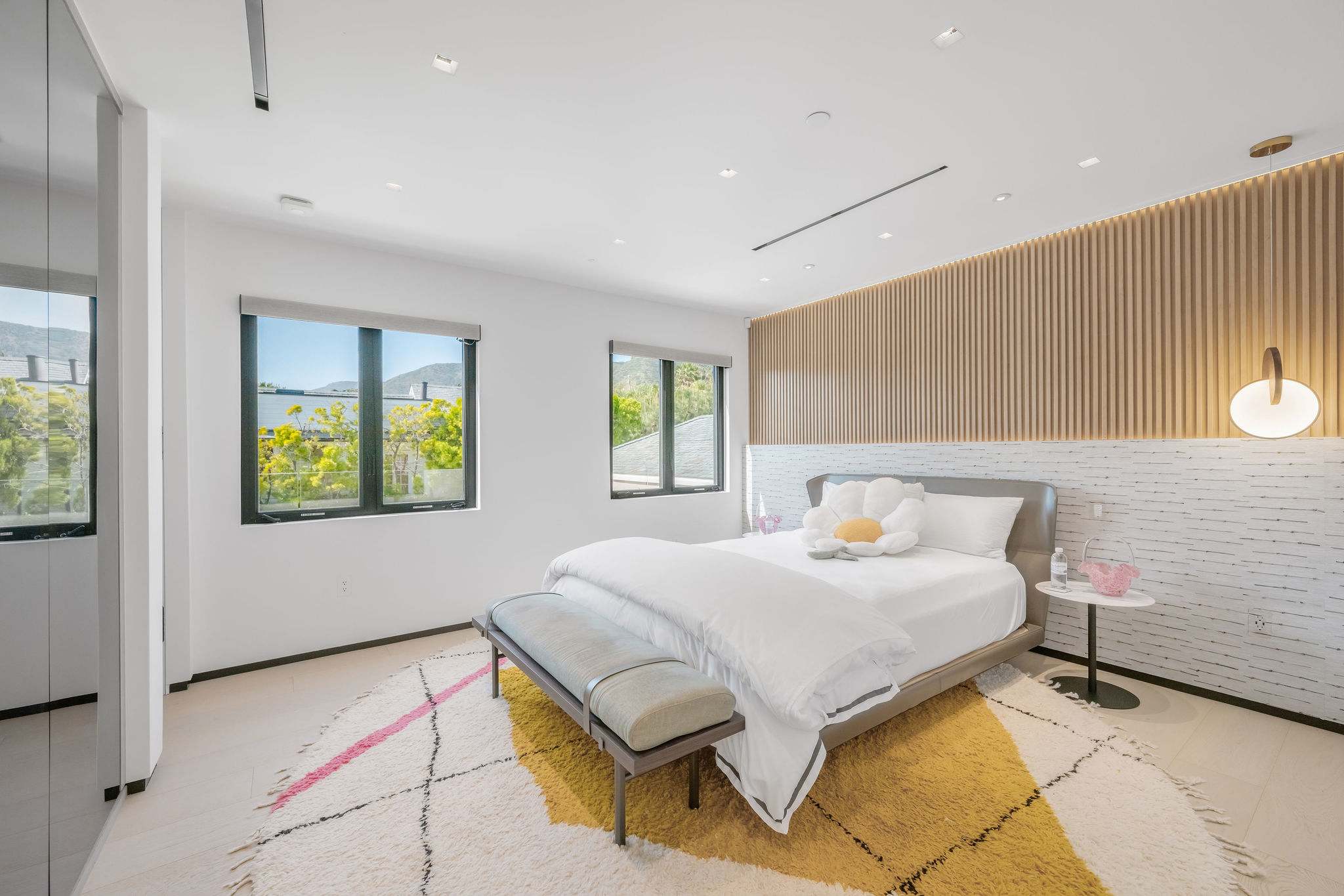Guest bedroom with wood paneling, soft finishes, and integrated seating.