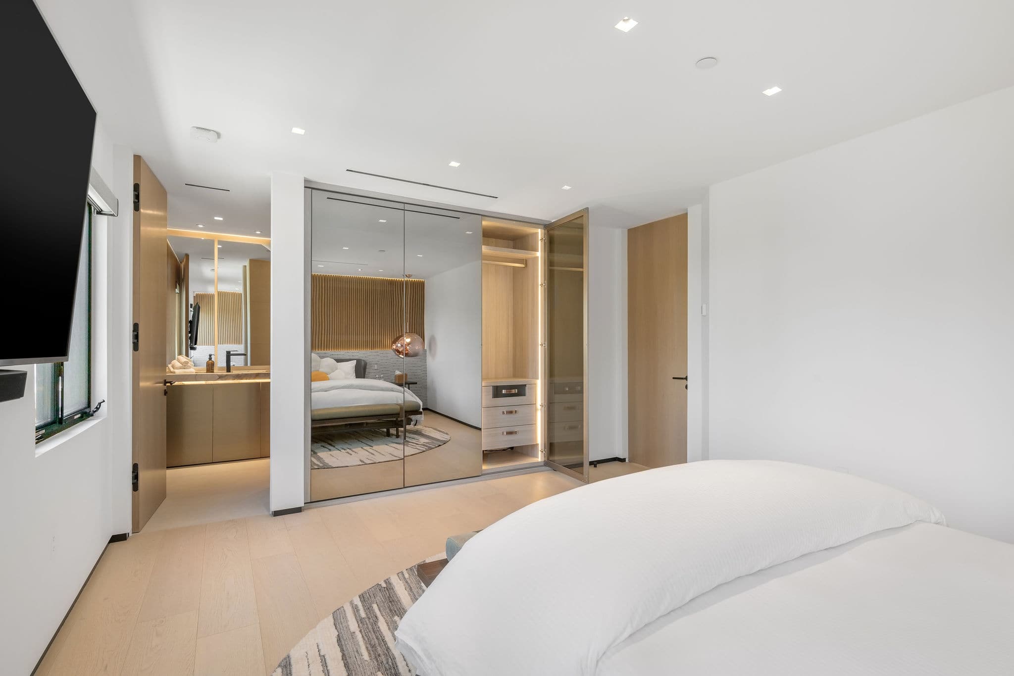 Bedroom with built-in storage and mirrored wardrobe detailing.