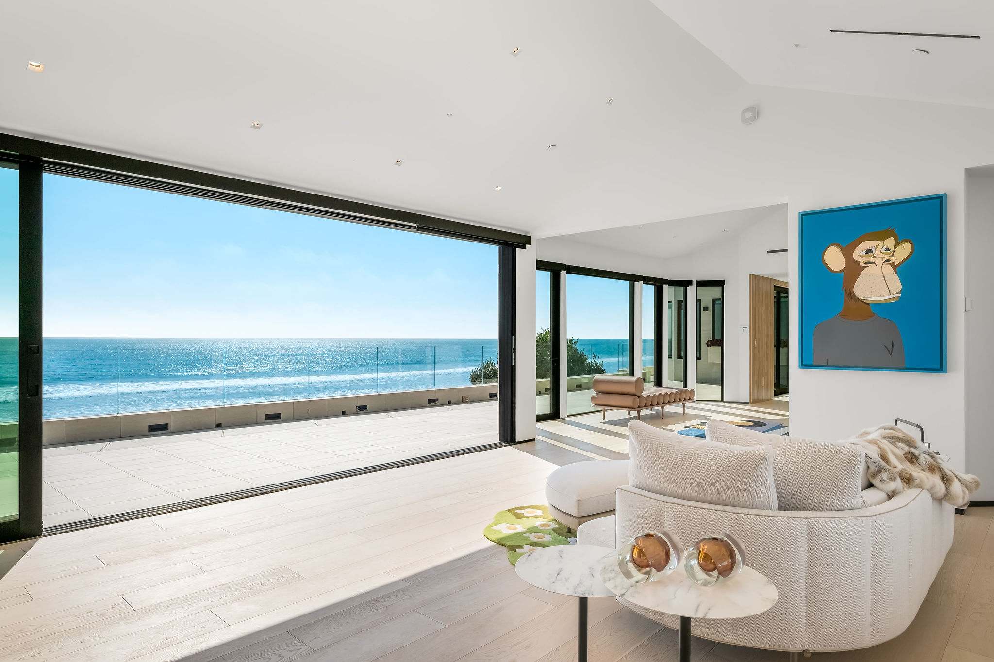 Open living area with retractable glass walls and direct oceanfront deck access.