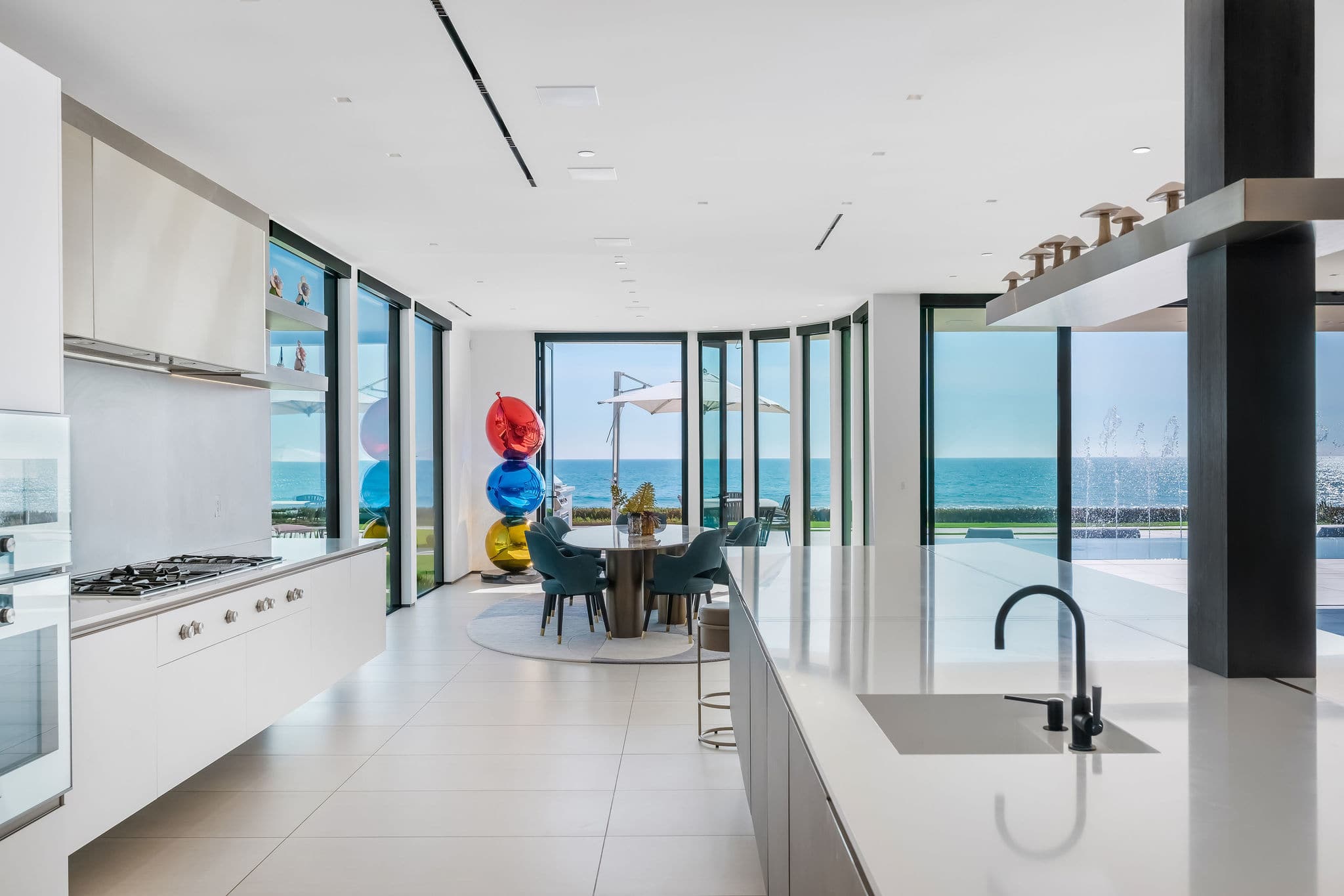 Gaggenau kitchen with oversized island and open-plan dining overlooking the ocean.