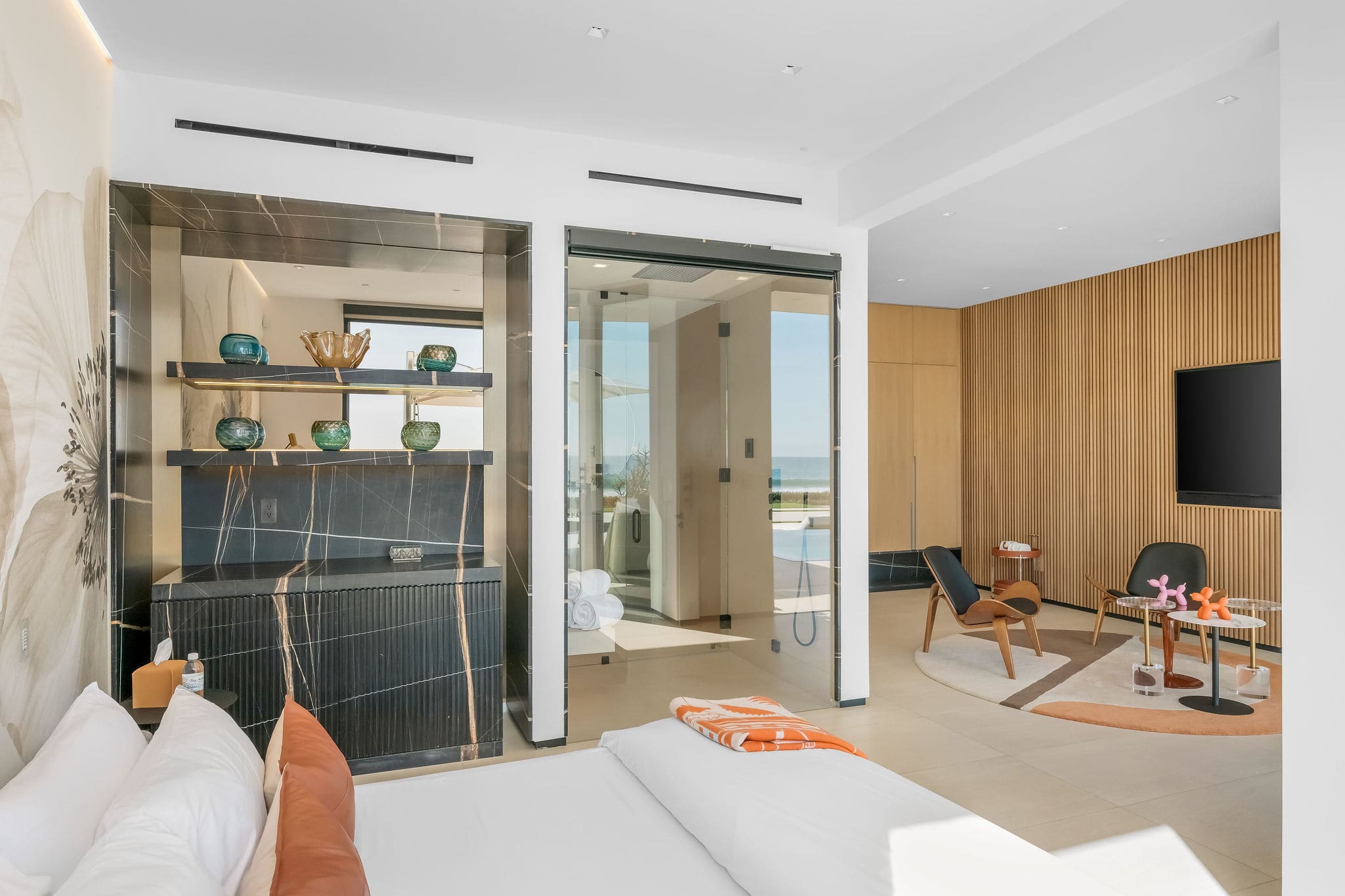Primary-style bedroom with lounge seating, media wall, and wood paneling.