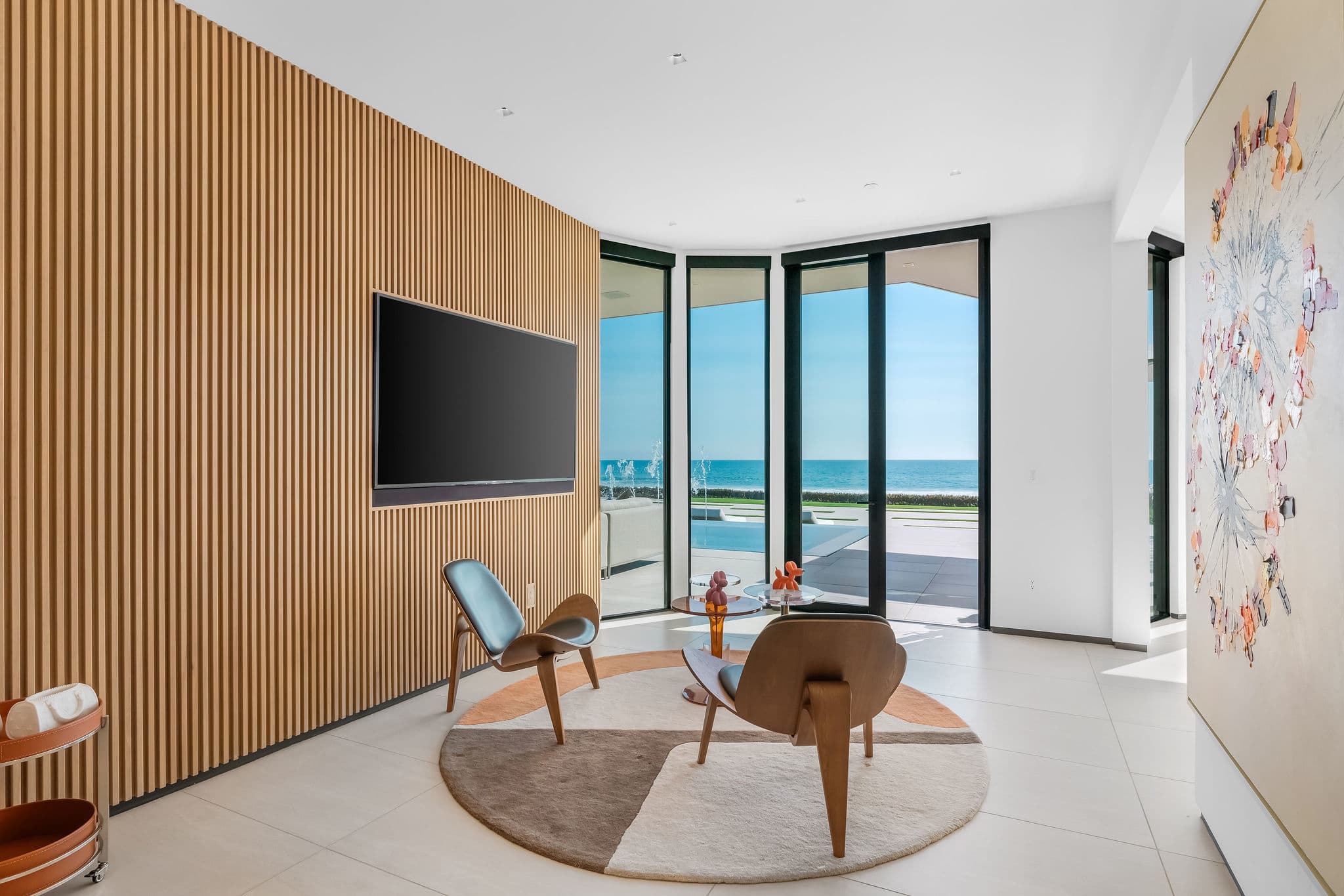 Private sitting area with curved glass walls and ocean-facing outlook.