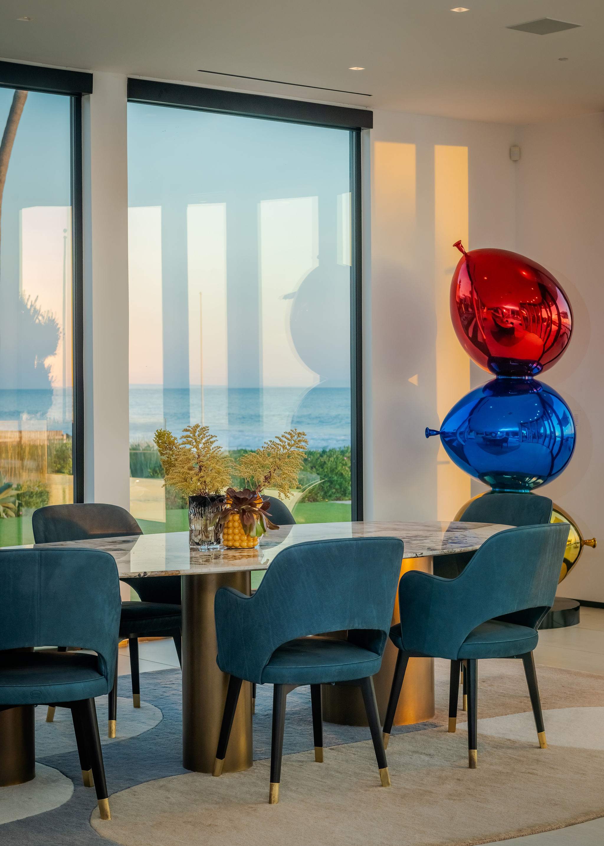 Gather around the dining table set beside floor-to-ceiling glass and ocean light.