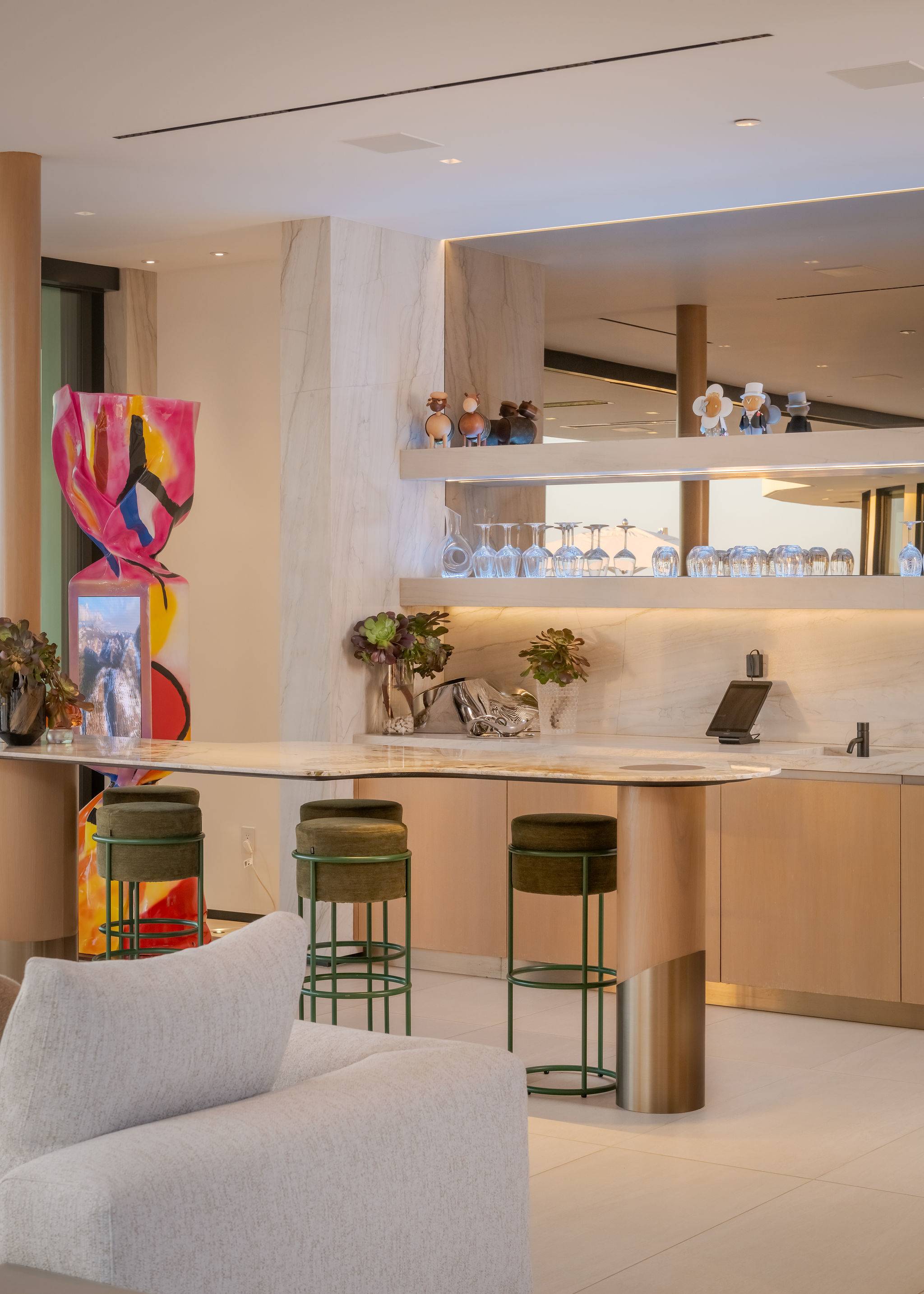 Custom bar with open shelving, integrated seating, and designer finishes.